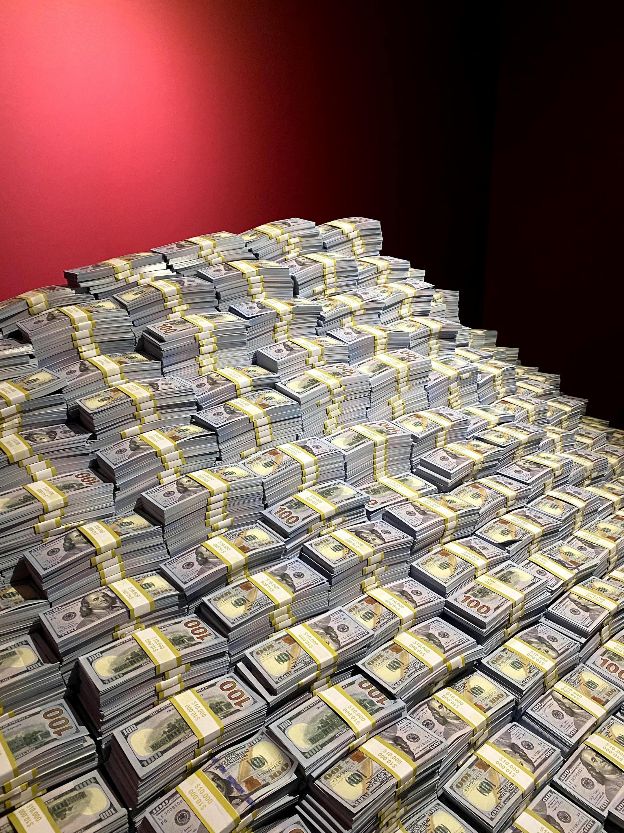 Impressive art installation of money stacks resembling a mountain, symbolizing wealth.