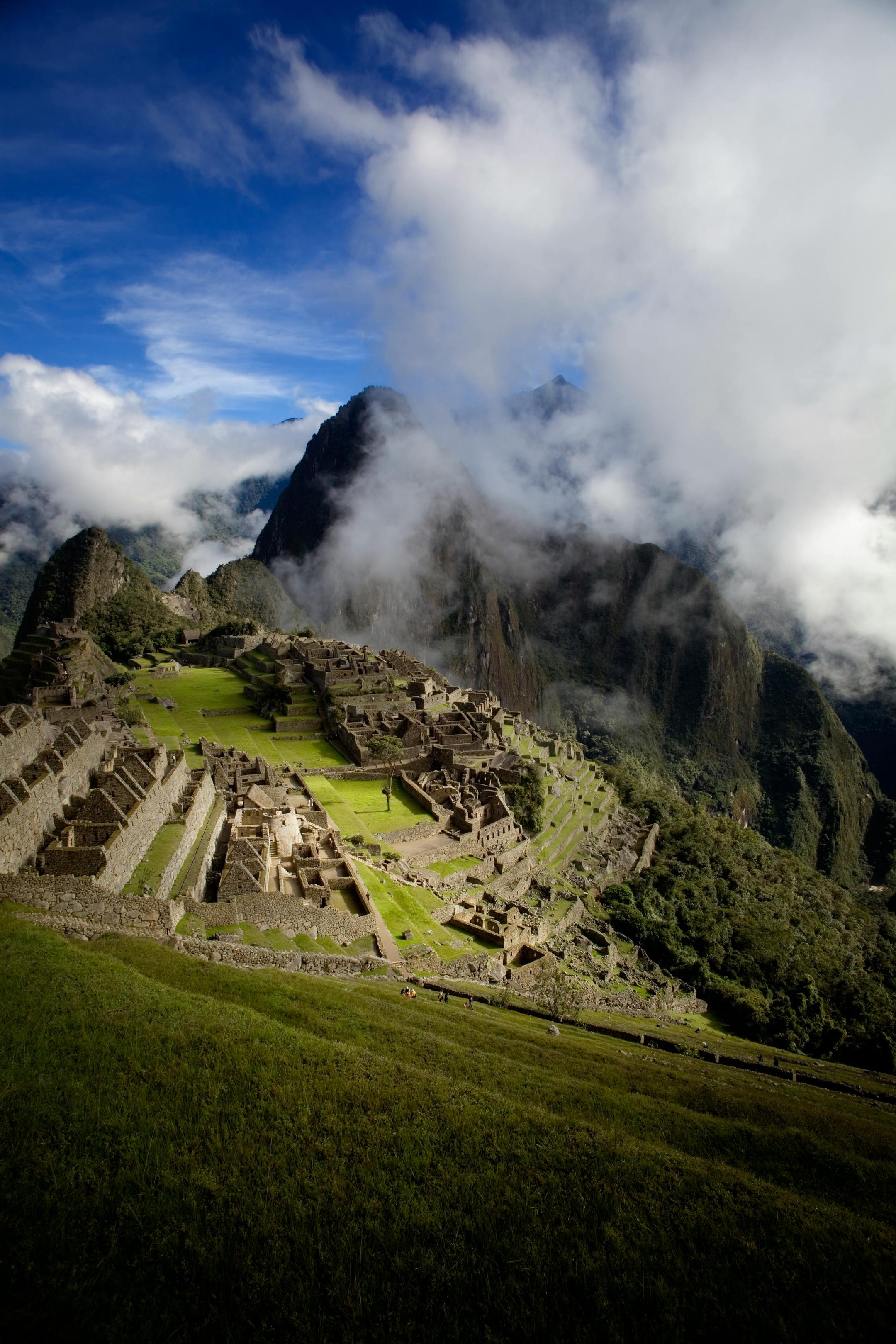 Breathtaking capture of Machu Picchu with dramatic clouds and mountains in Peru.