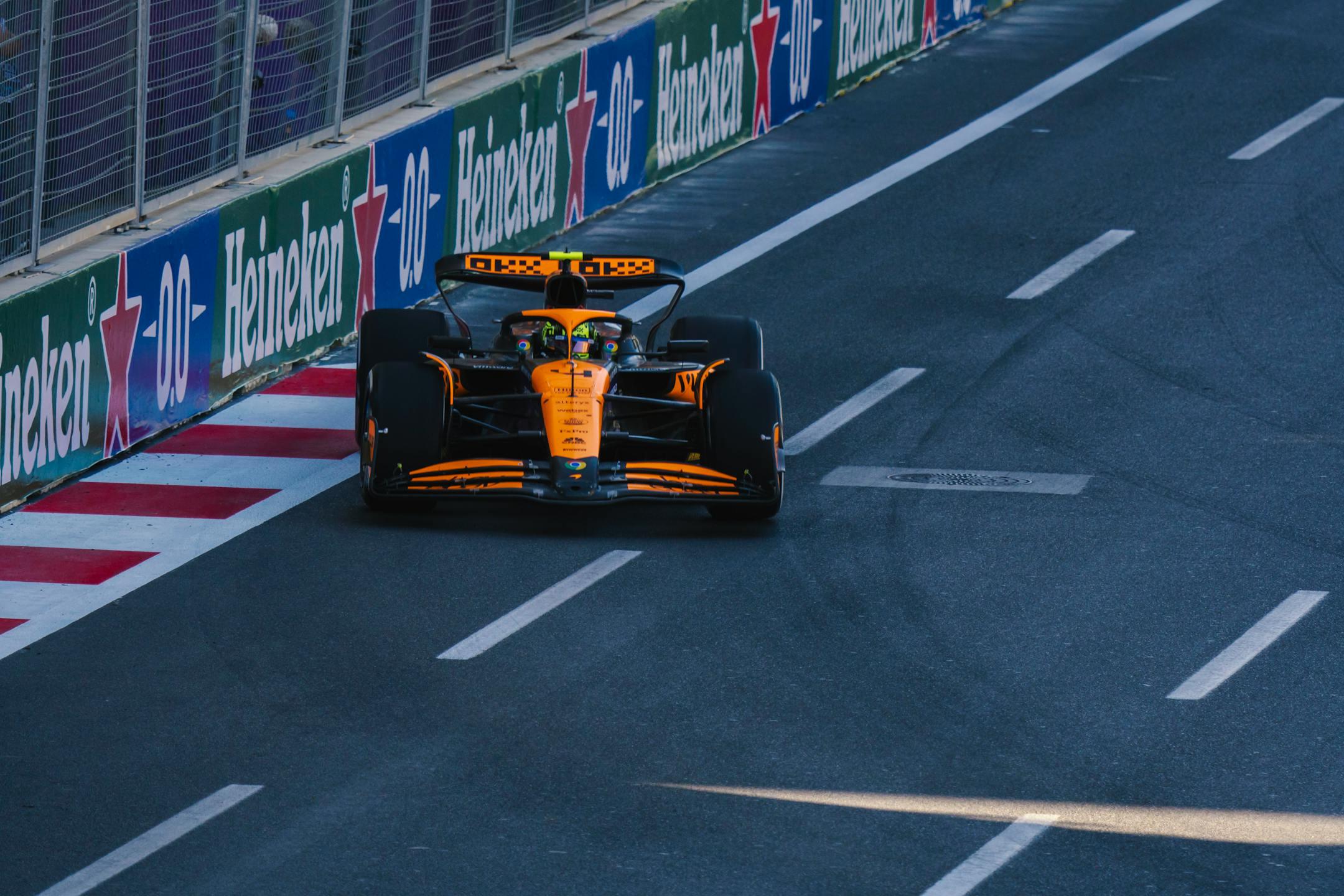 A Formula 1 racing car speeding along the Baku City Circuit during a race event.