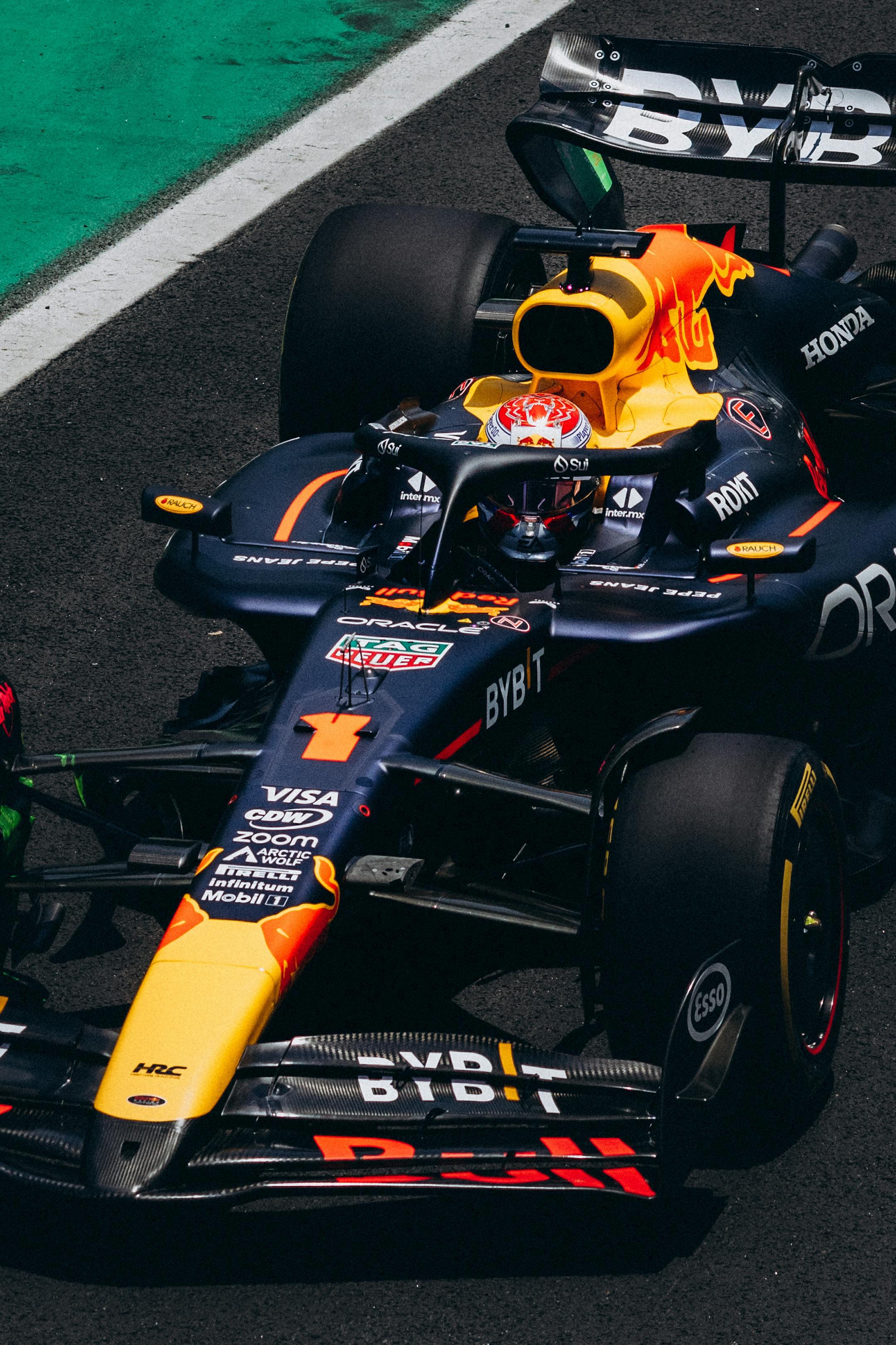 Overhead view of a Formula 1 car racing on a track, displaying vibrant sponsor logos.