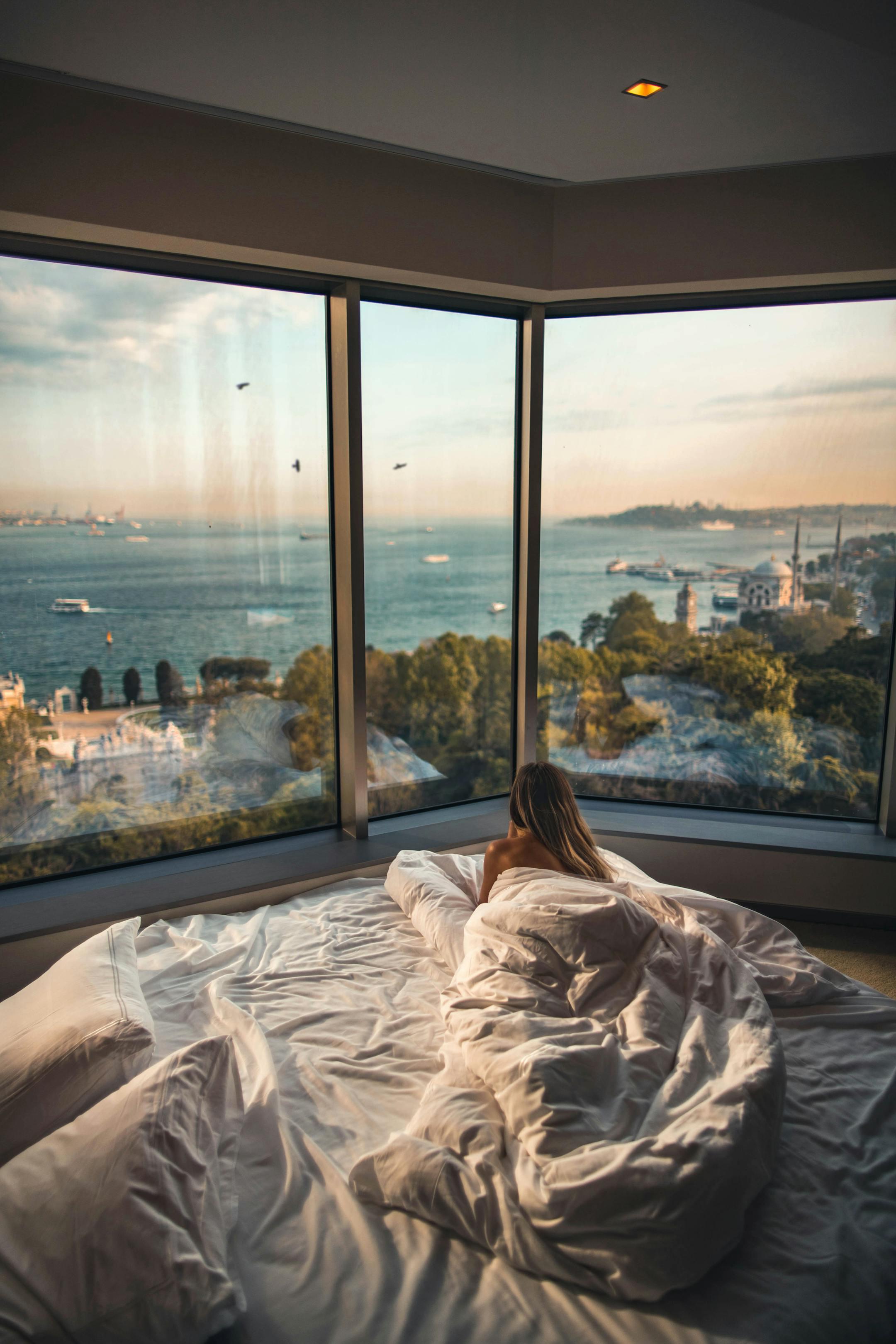 Relaxing in a cozy hotel room with stunning views of the Bosphorus at sunset in Istanbul, Turkey.