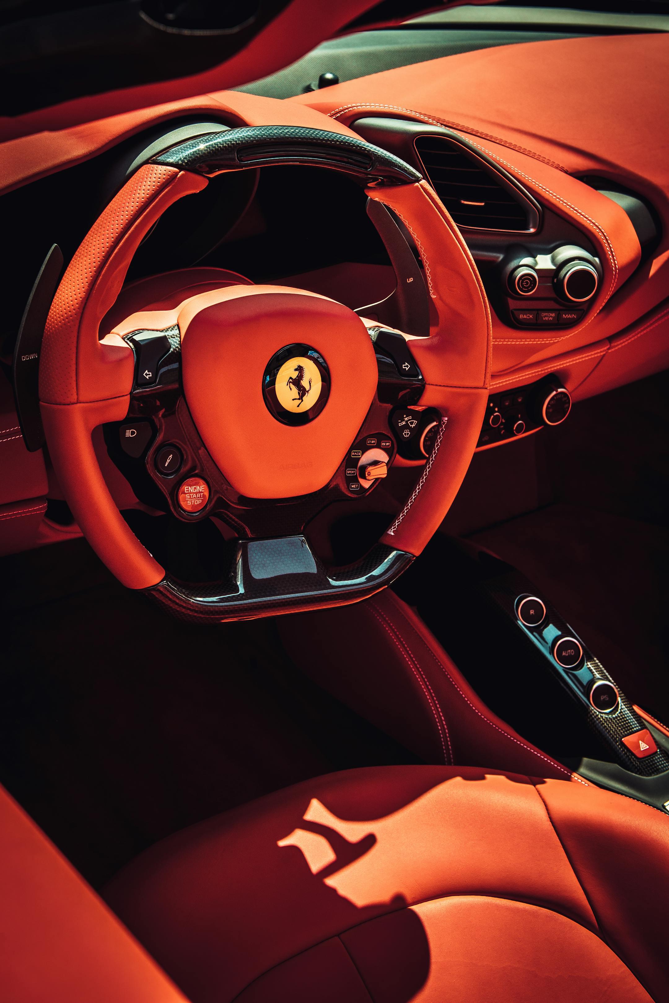 Close-up of a luxurious red interior of a sports car featuring a stylish steering wheel.