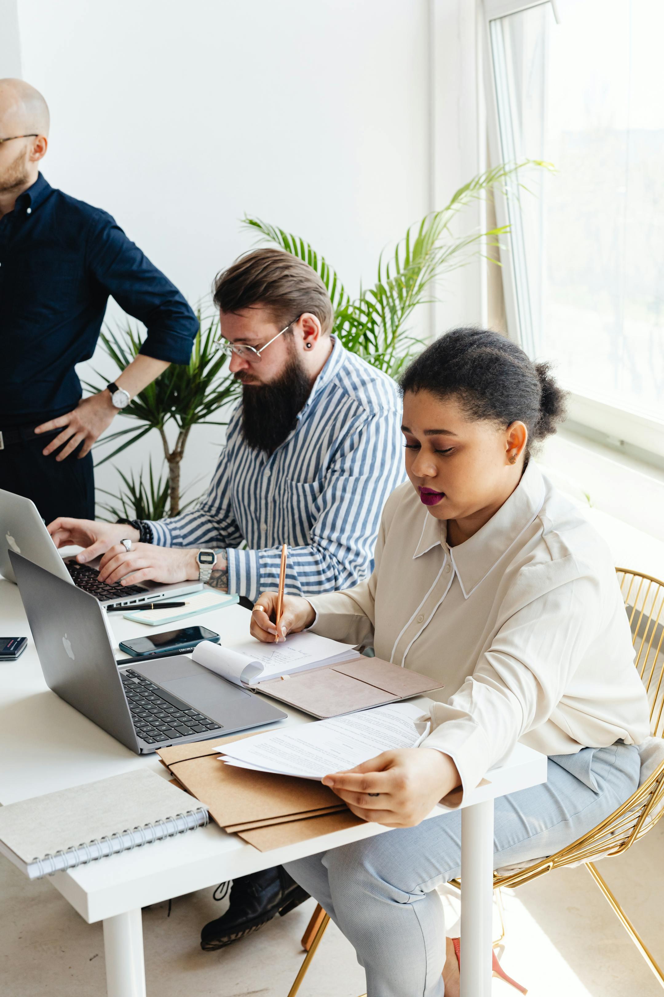 A diverse group of professionals working together in a modern, well-lit office setting.