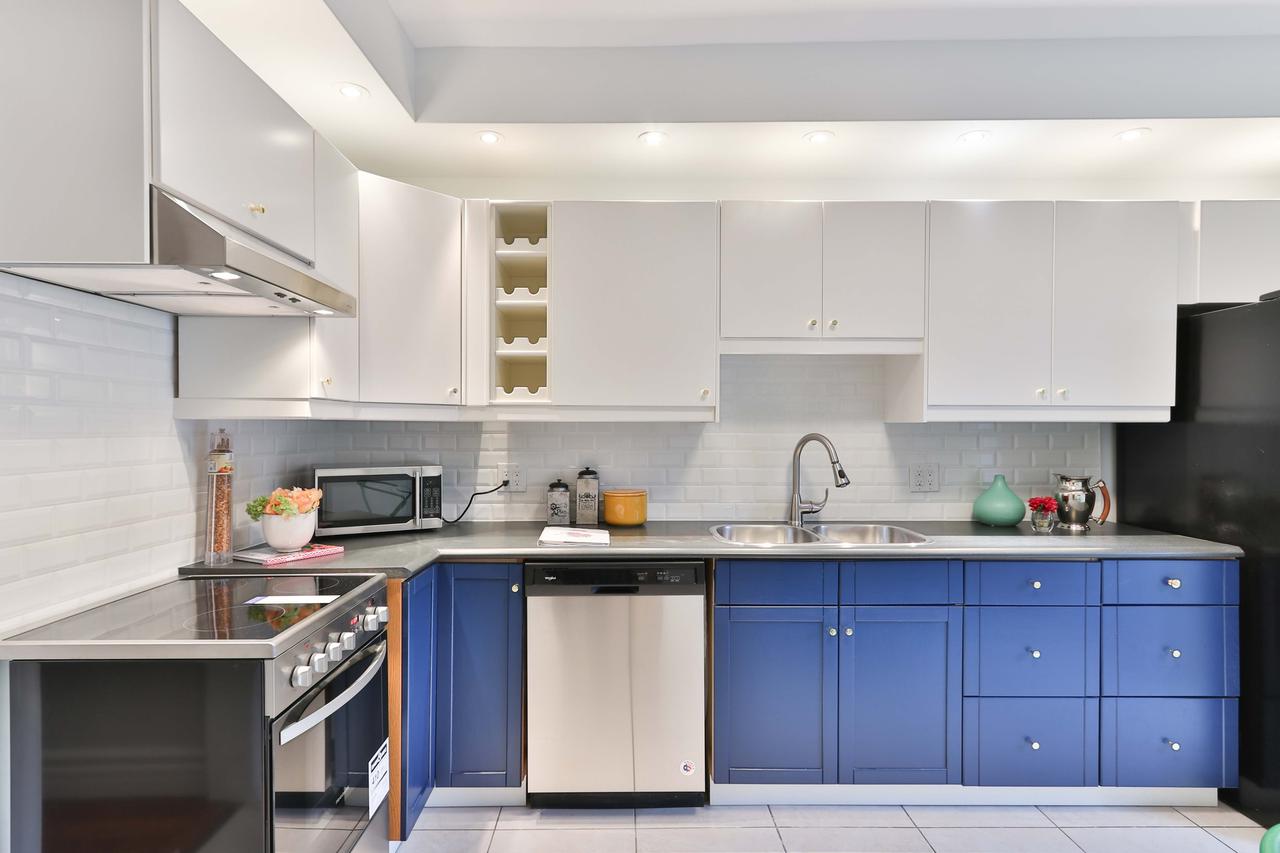 A kitchen with white and blue cabinets.