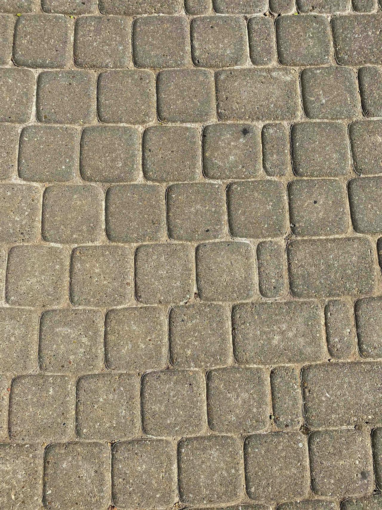 Detailed image of a textured stone pavement with a square pattern, ideal for backgrounds.
