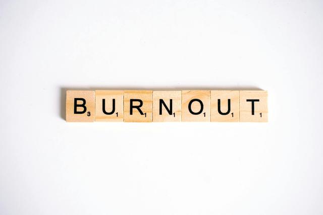 Conceptual image of 'Burnout' spelled with Scrabble tiles on a white background.