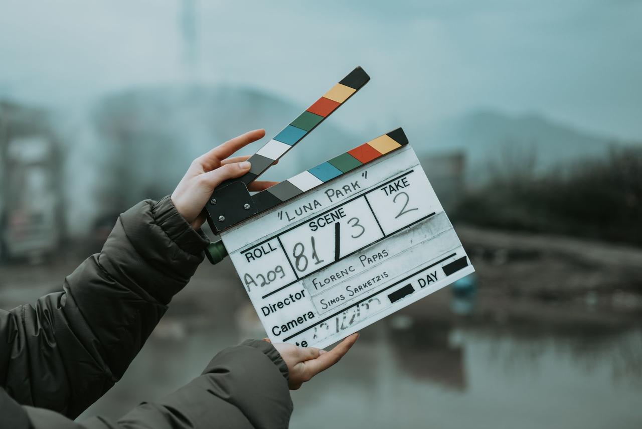 Close-up of a film clapperboard on an outdoor set, signaling scene start.