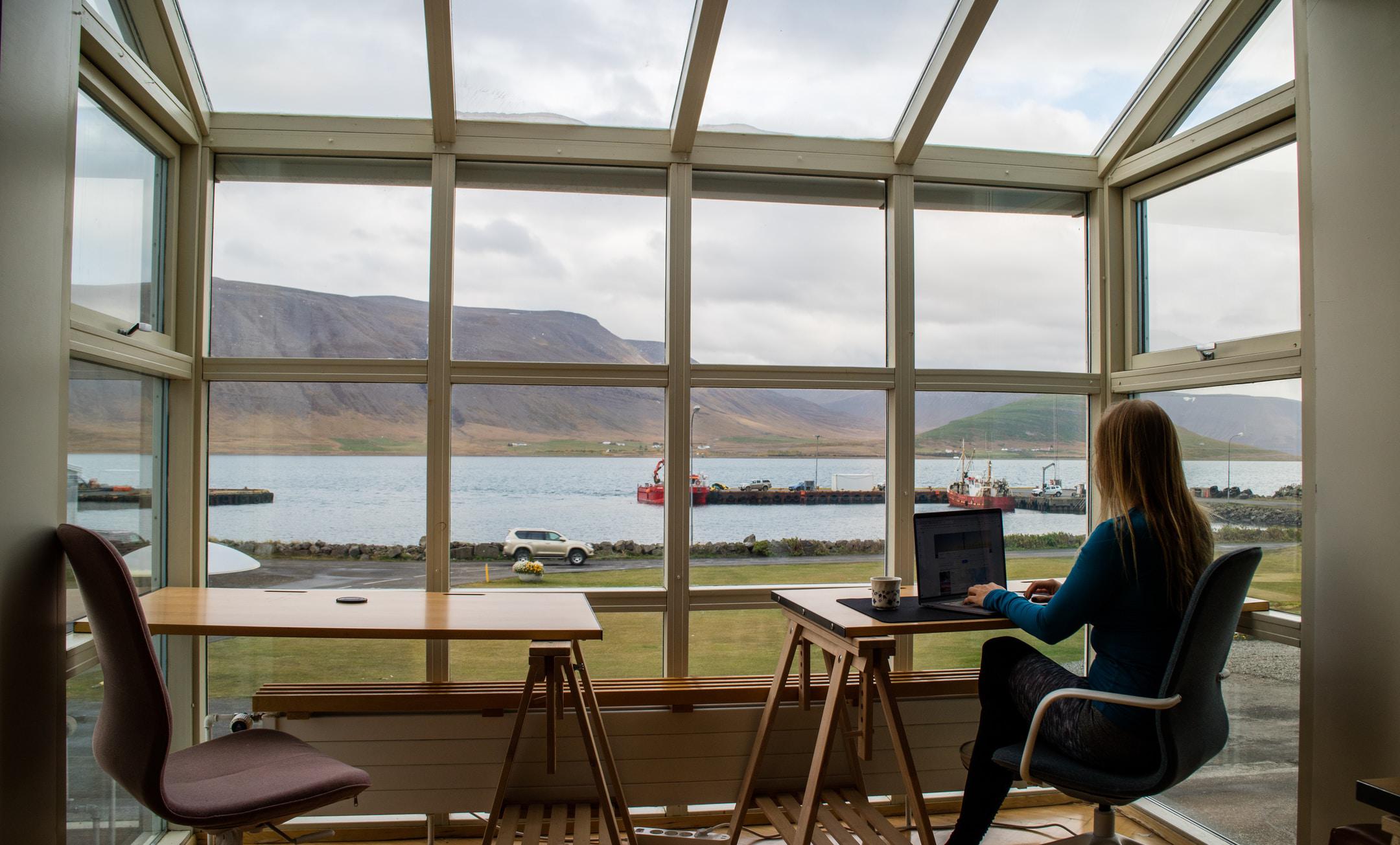 A woman working at a desk on a laptop.