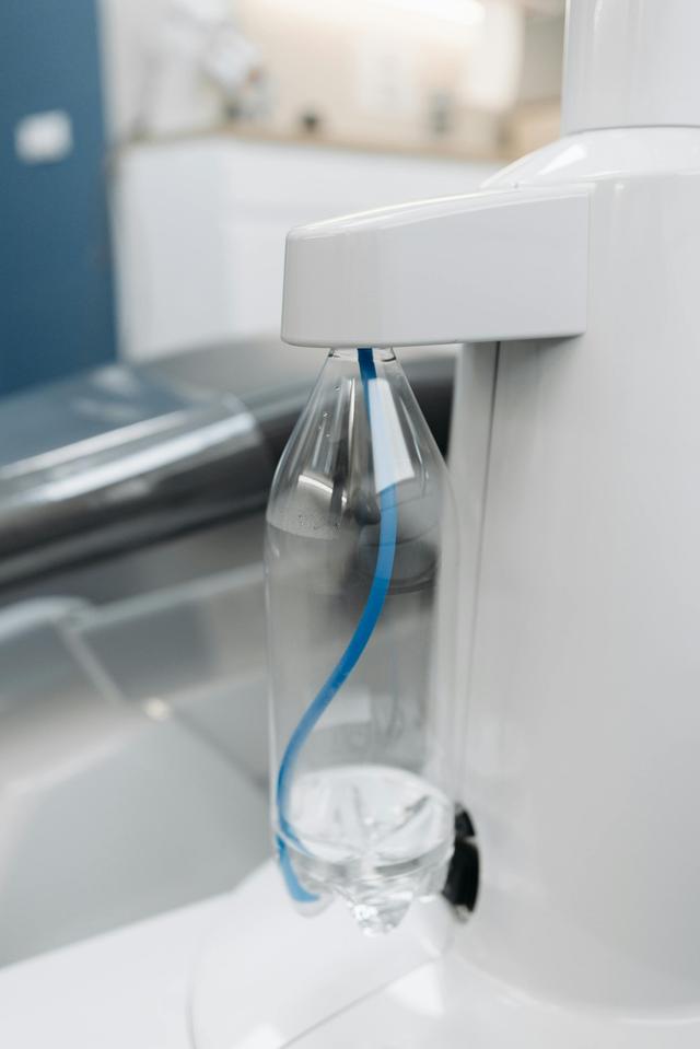 Clear plastic bottle attached to water dispenser in a modern office environment.