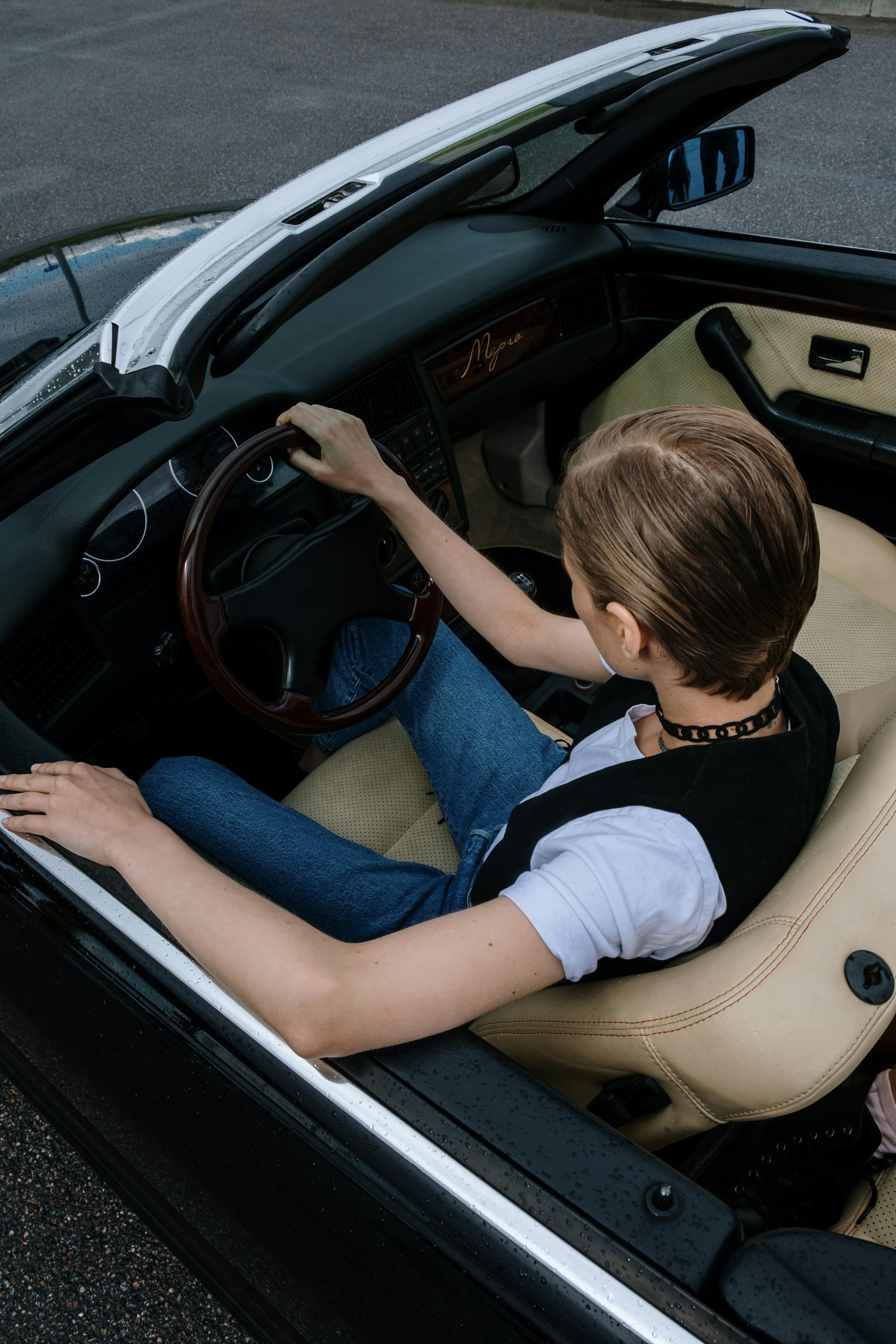Overhead view of a young adult driving a convertible, in need of a DUI lawyer after an incident