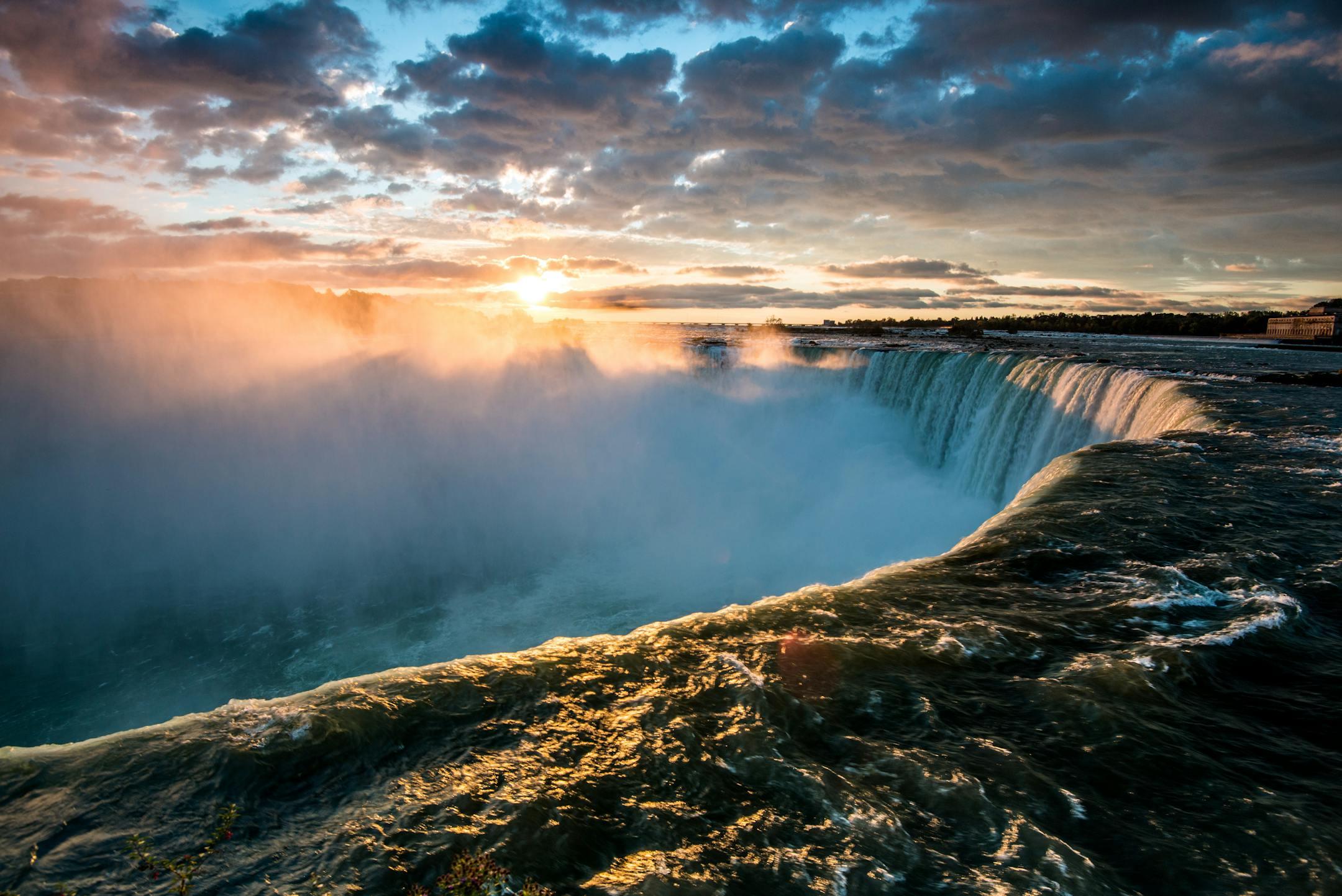 Experience the majestic beauty of Niagara Falls at sunset, capturing the vibrant colors and mist.