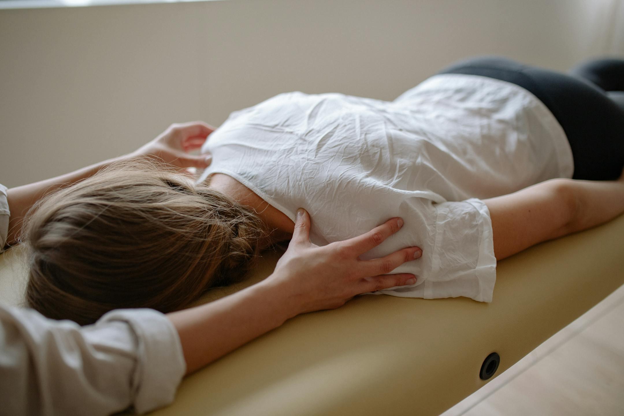 A woman receiving a calming massage therapy session on a comfortable table.