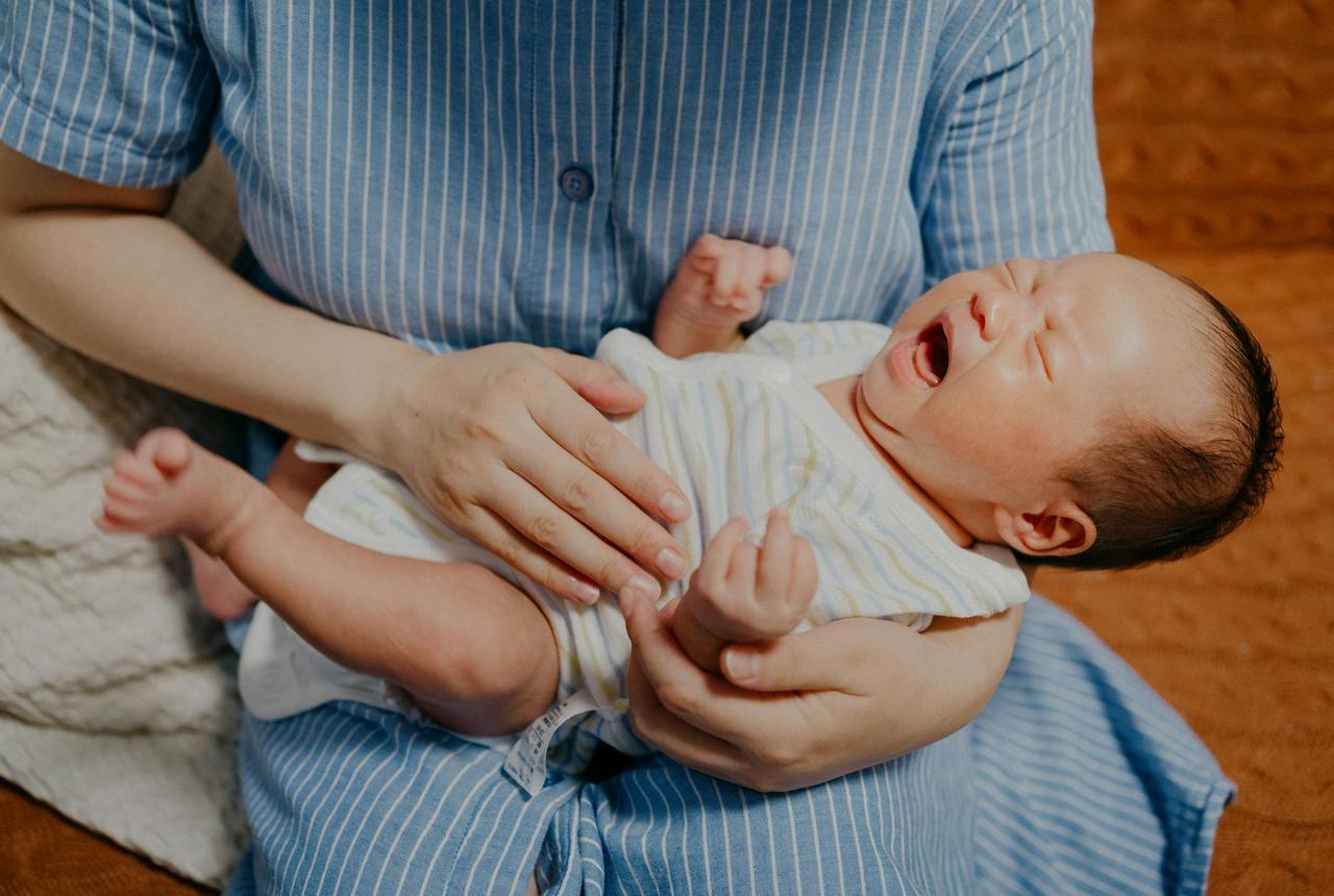 A tender moment of a mother cradling her newborn baby, showcasing love and care.