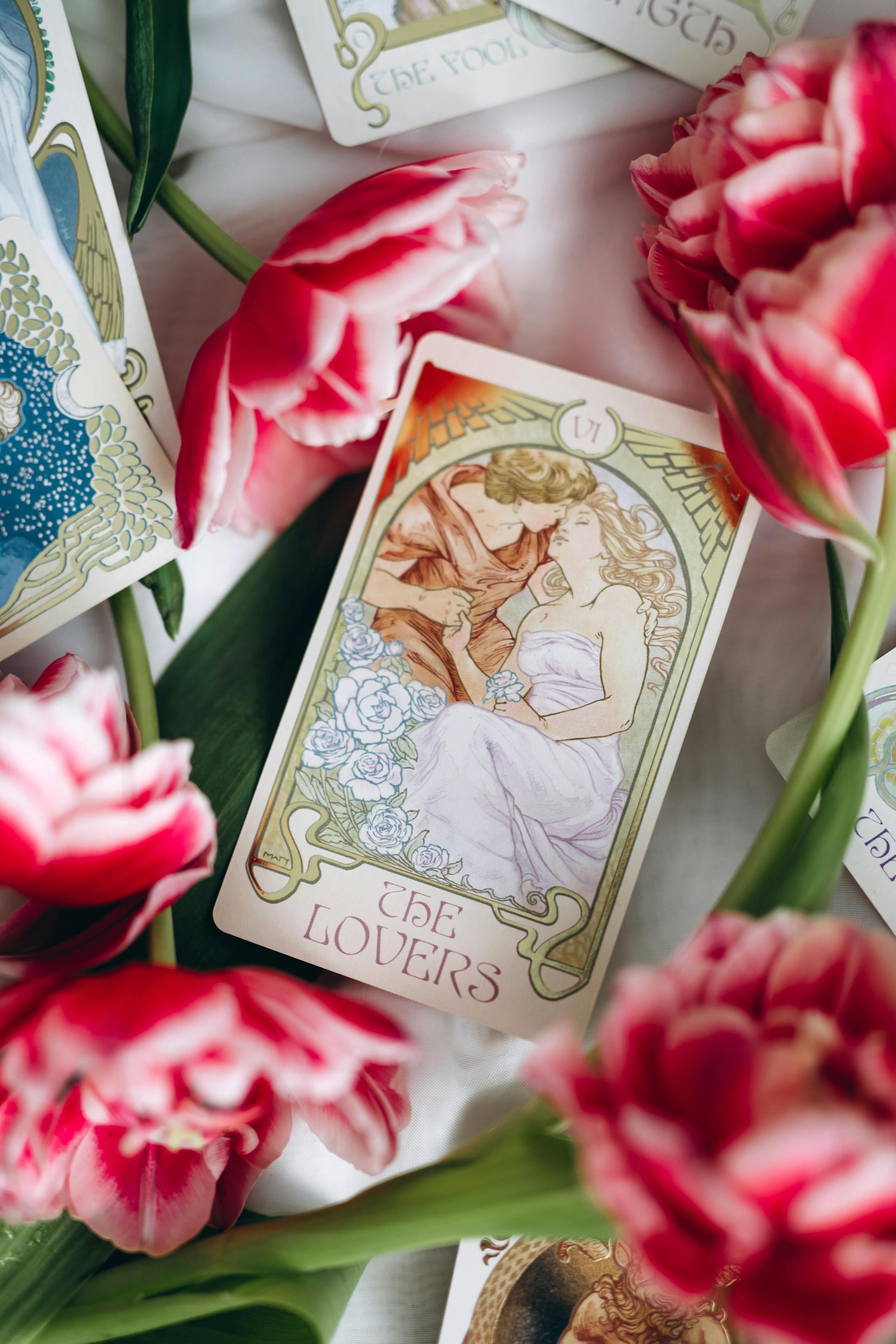 Tarot cards including The Lovers surrounded by vibrant pink tulips, capturing romance and divination.