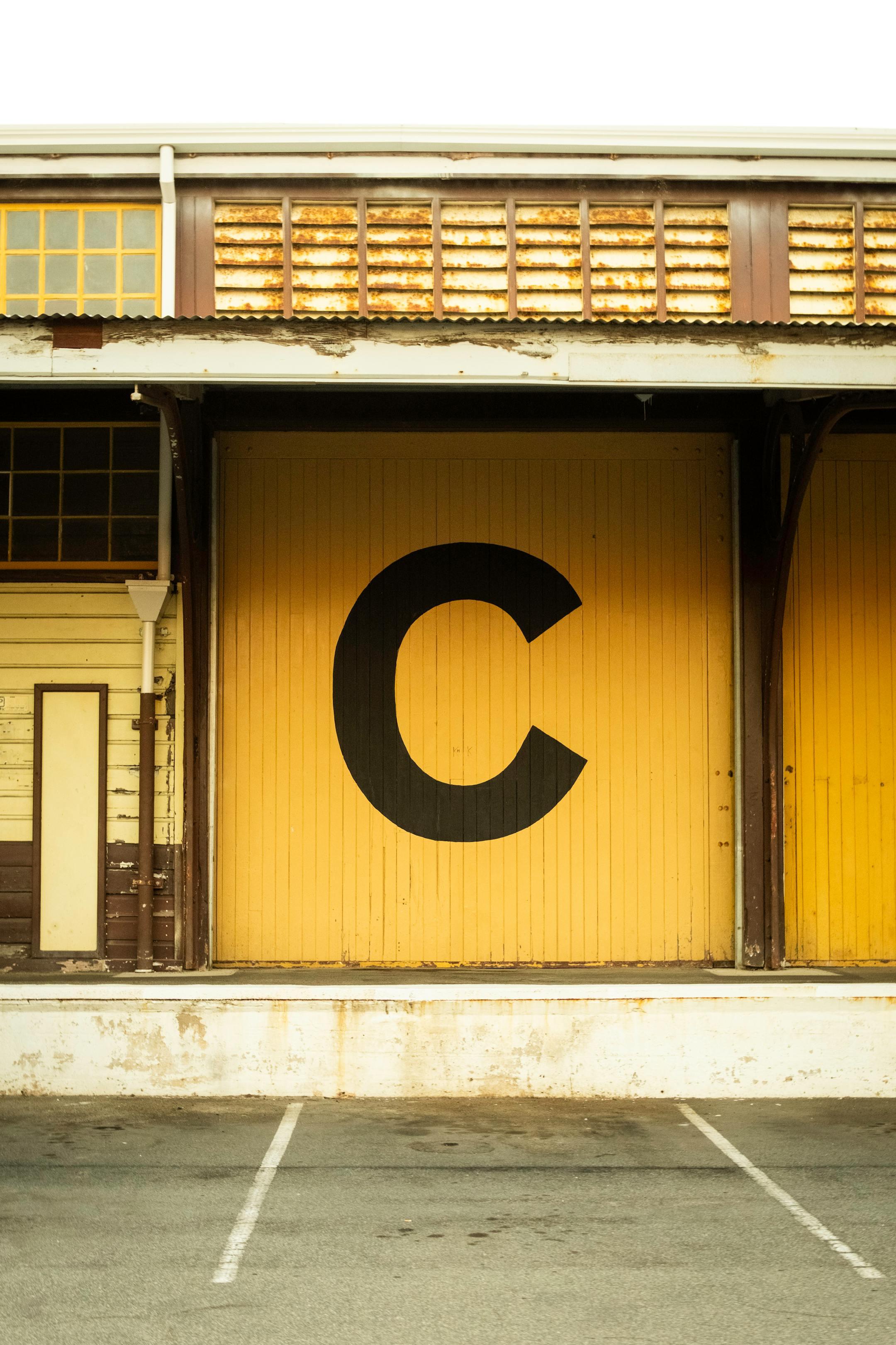 Yellow warehouse facade with letter 'C' in Fremantle, Western Australia.