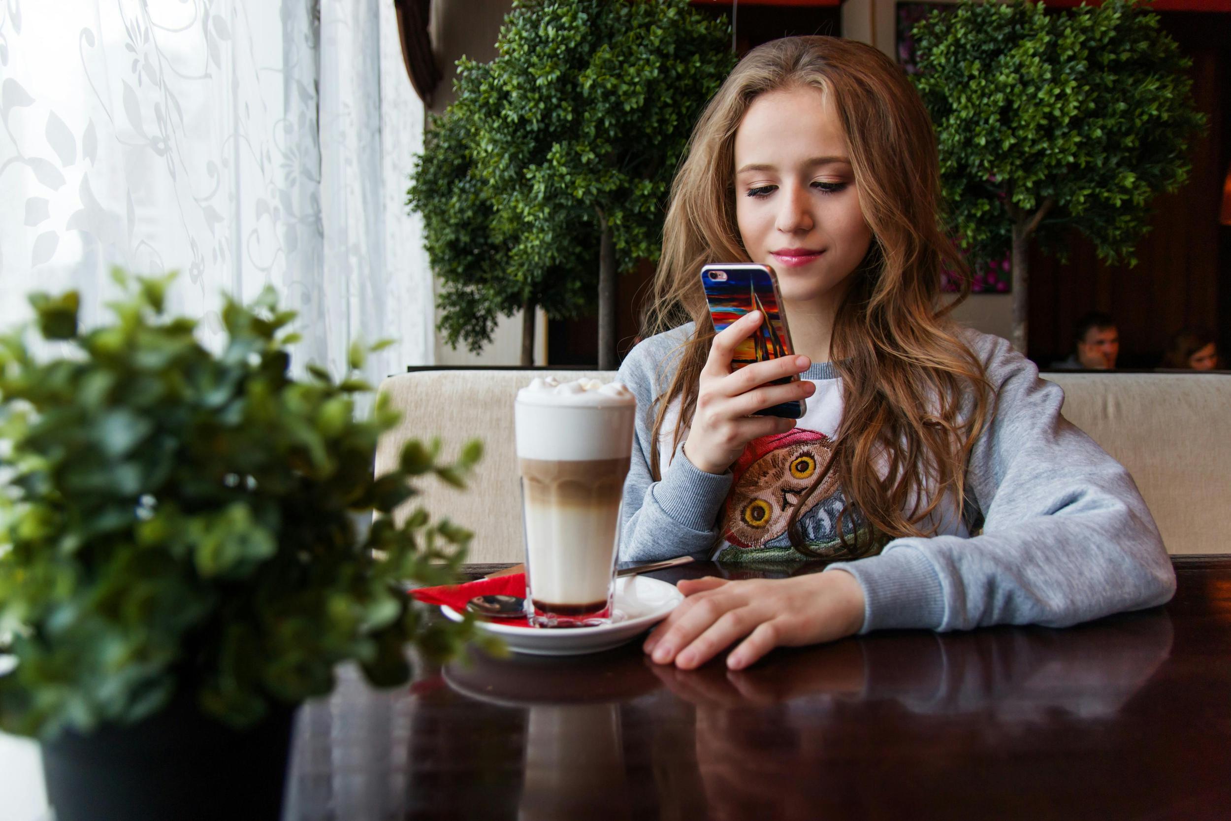 Girl at coffee shop with phone privacy screen
