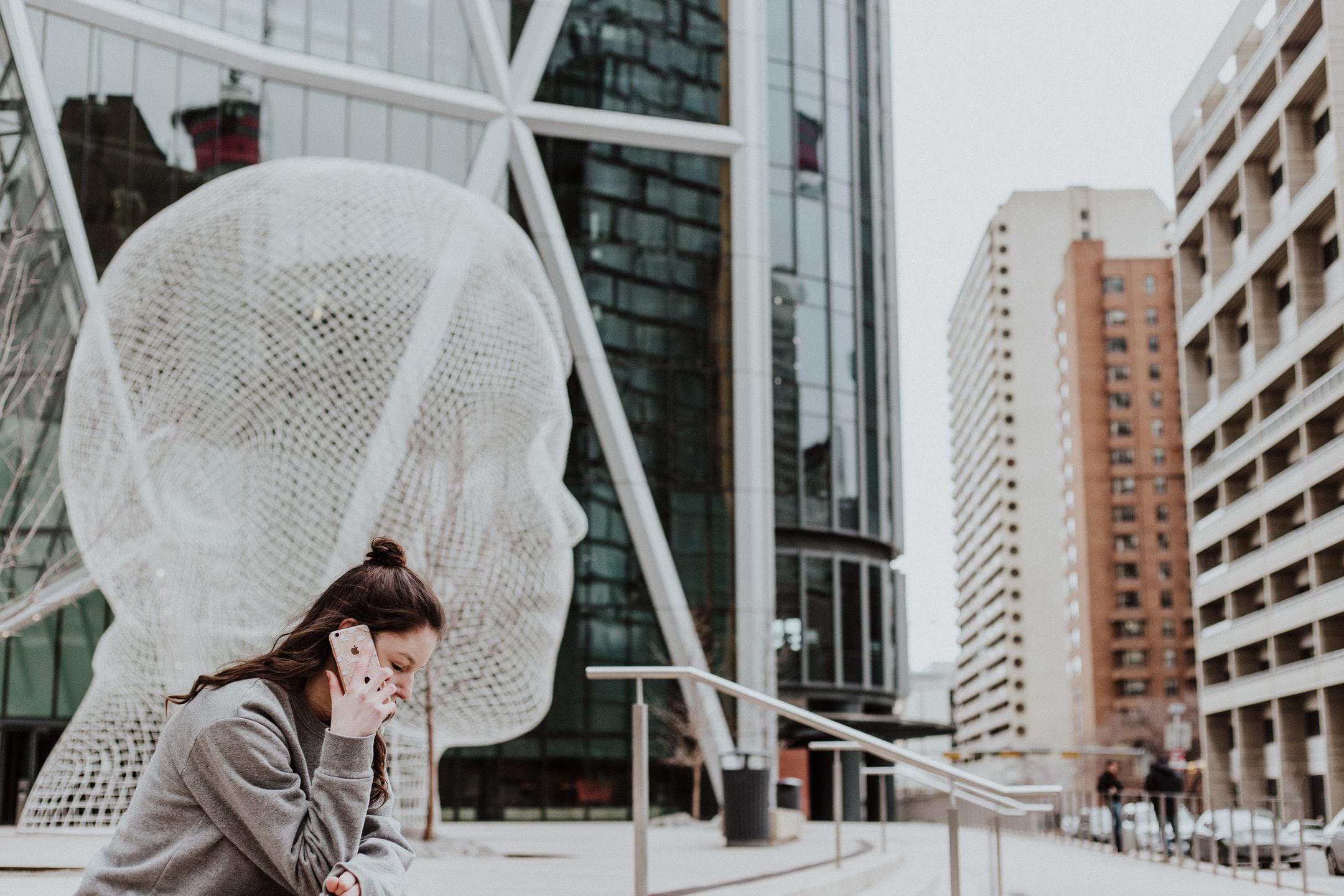 Image of someone taking a phone call in a city center after using a security robocall blocker.
