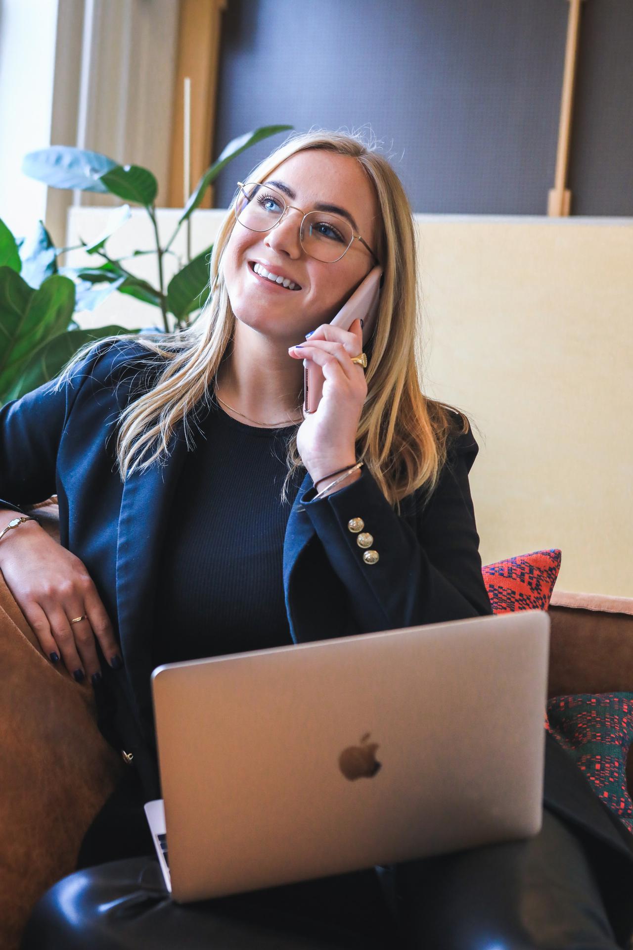 A businesswoman taking a break from working on her laptop to have a friendly phone conversaton. Whether international or domestic, the TRACED Act will impact your calls. It&#x27;s important to understand how.