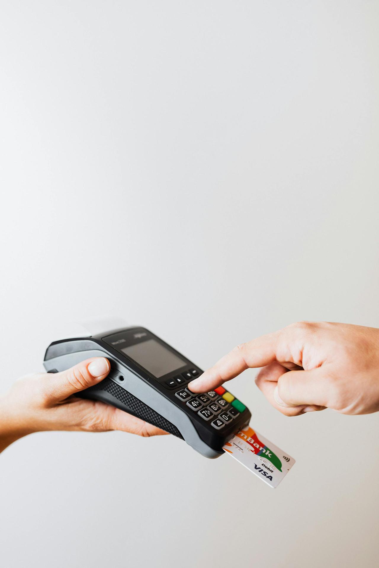 Close-up of card payment using POS terminal, emphasizing cashless transaction.