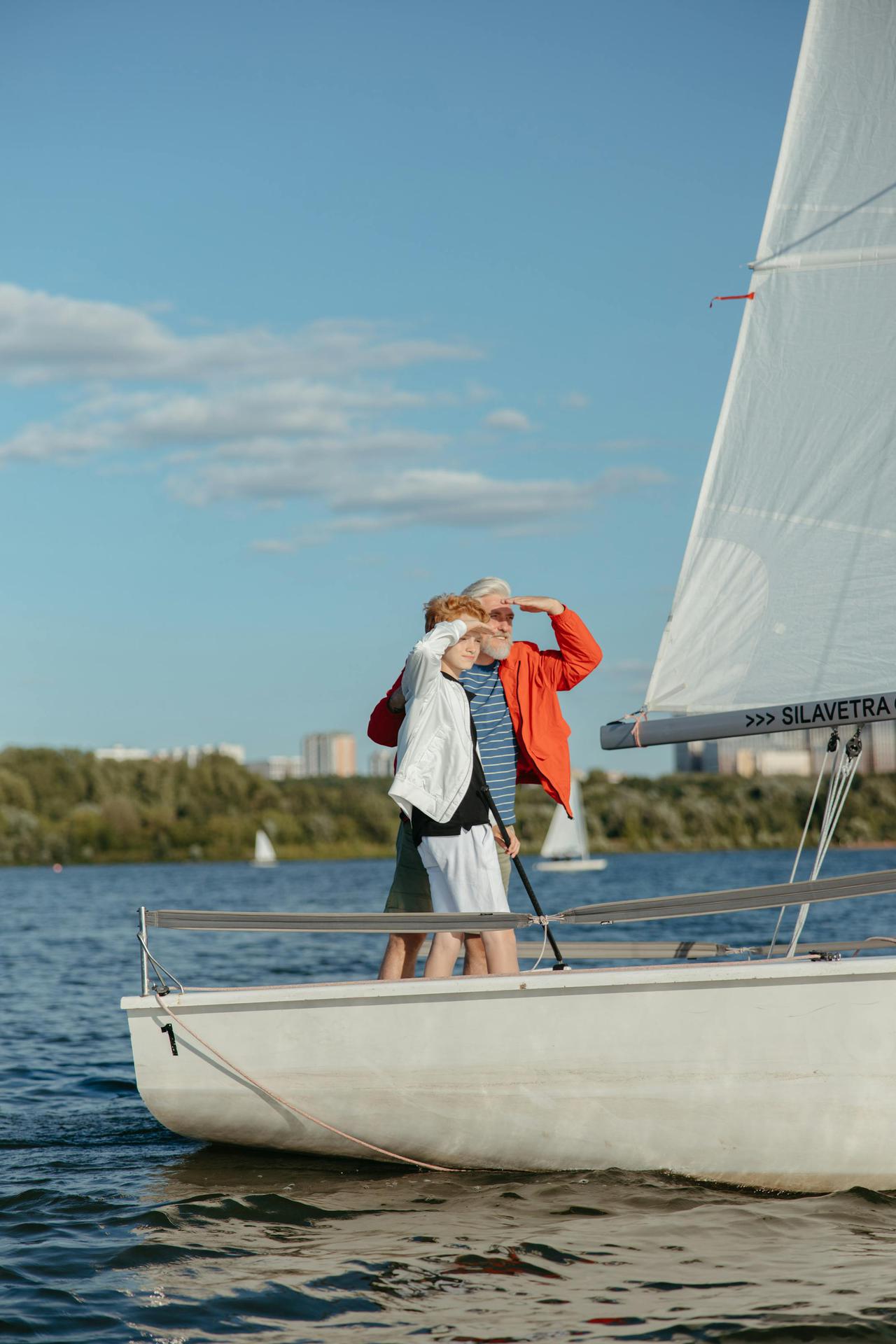 A grandfather and grandson enjoying a sailboat ride on a sunny lake, bonding and exploring together.