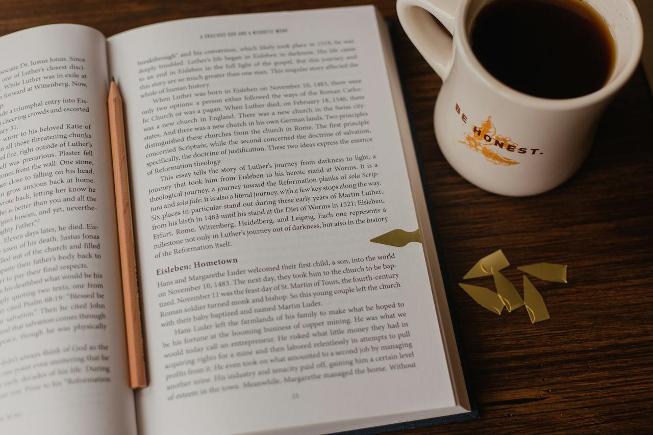 An open book and cup of warm tea.