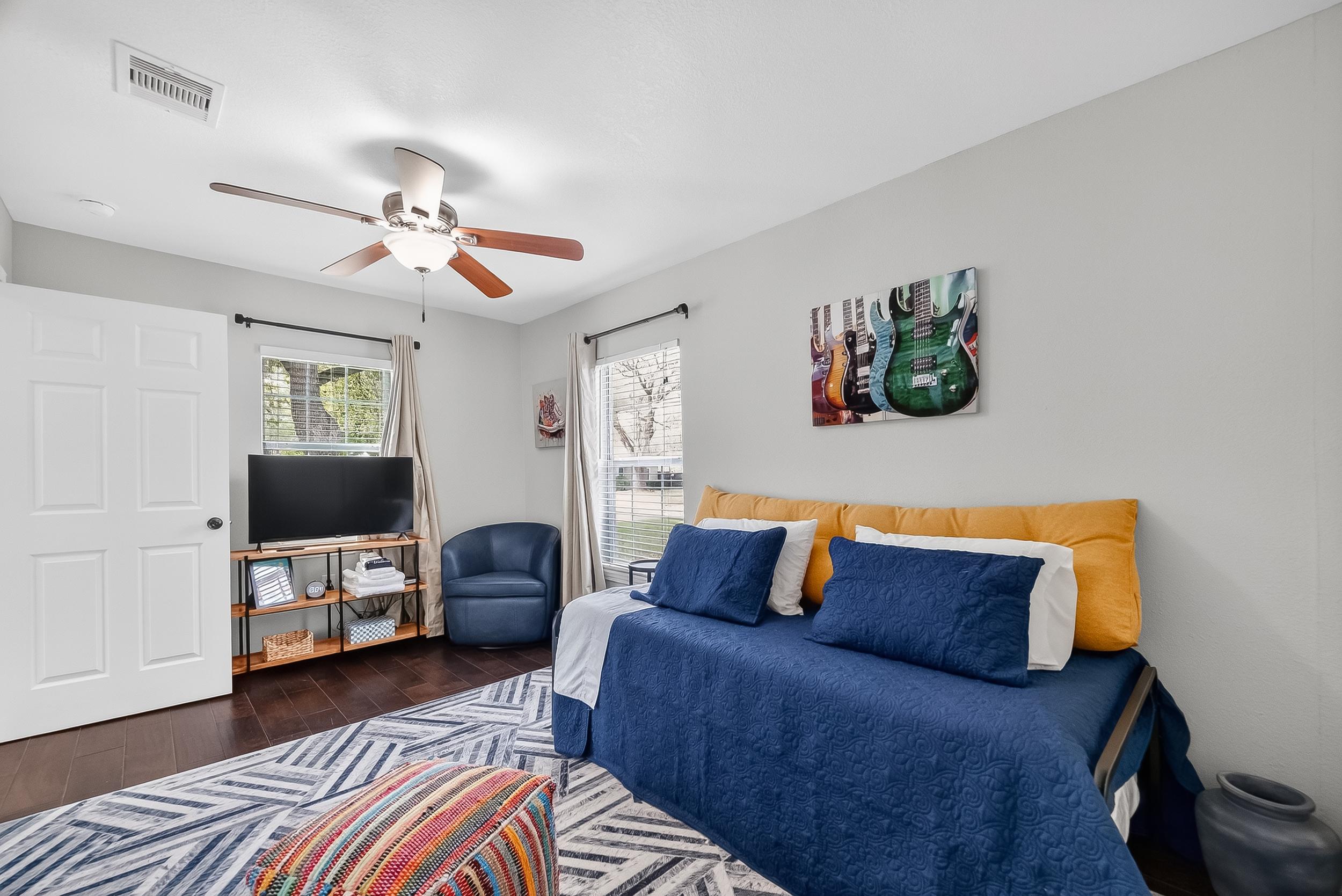 Furnished rental bedroom with seating area and television
