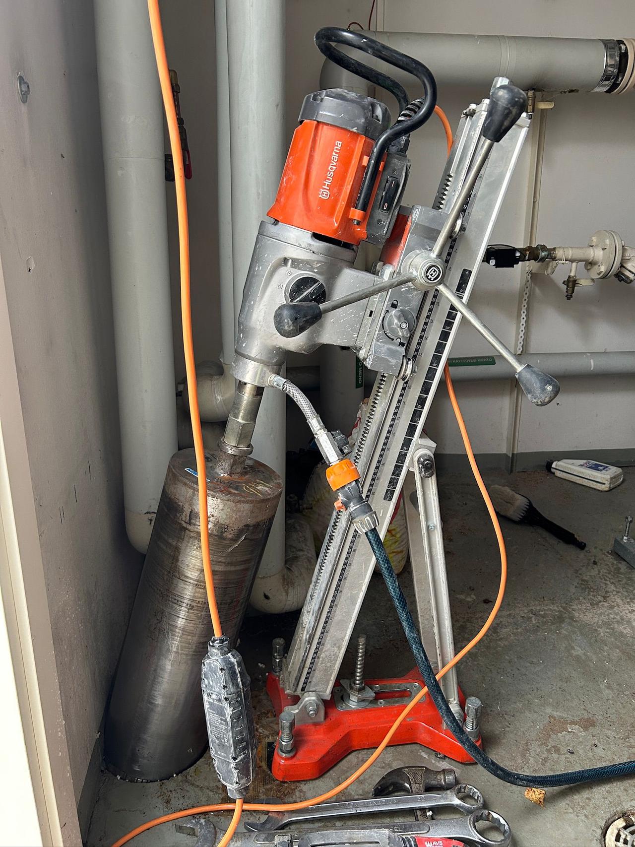 Lämpökanaalien, vesiputkien sekä sähköjohtojen suojaputkien timanttiporaus viistossa kivijalan läpi.