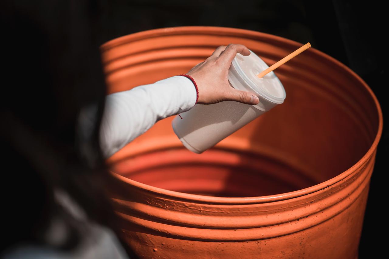 Image of someone throwing away a cup with a high plastic grade.
