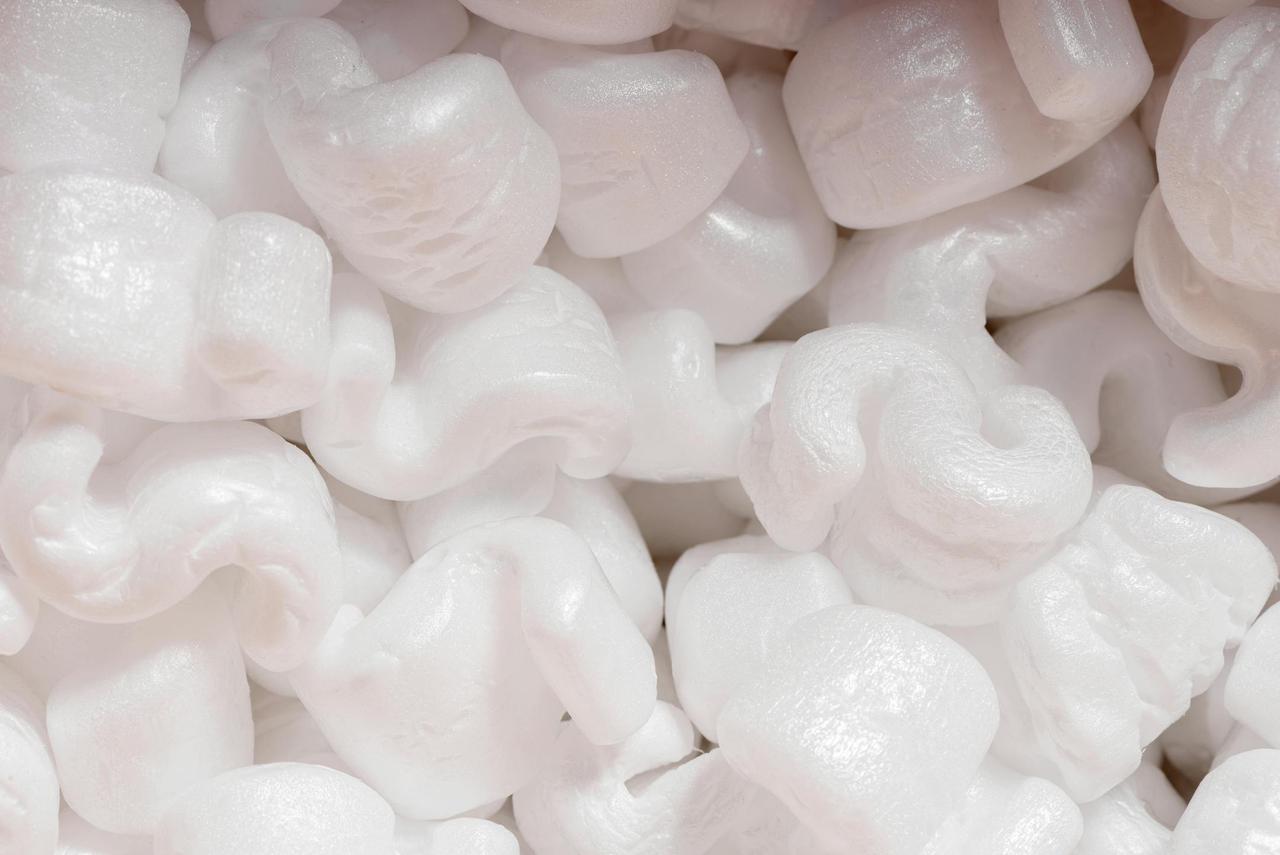 Detailed view of white polystyrene packing peanuts used for protective packaging.