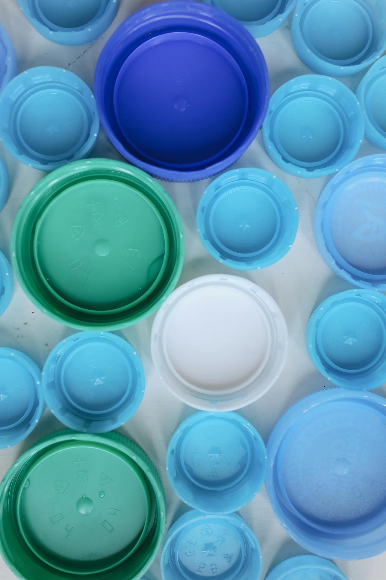 Aerial view of assorted colorful plastic bottle caps highlighting recycling and sustainability.
