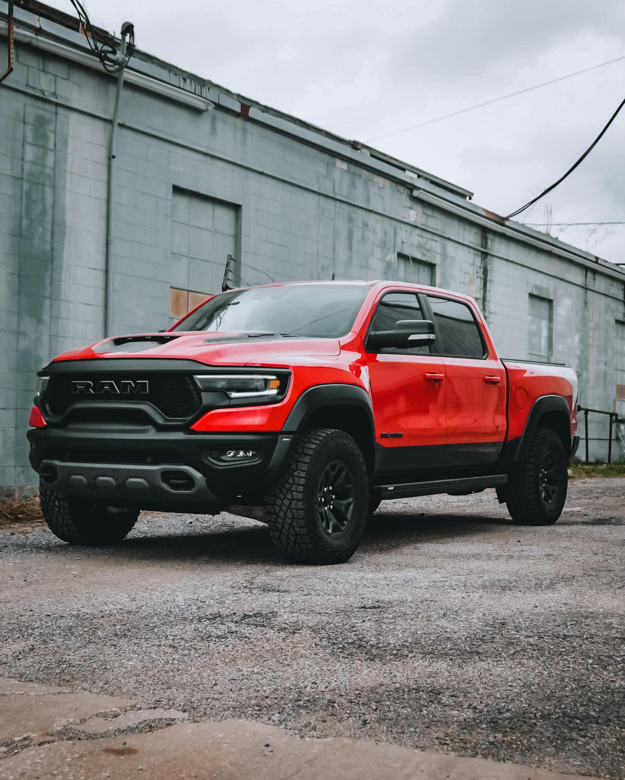 Red RAM truck with custom rims parked in an industrial area in Tulsa, OK.