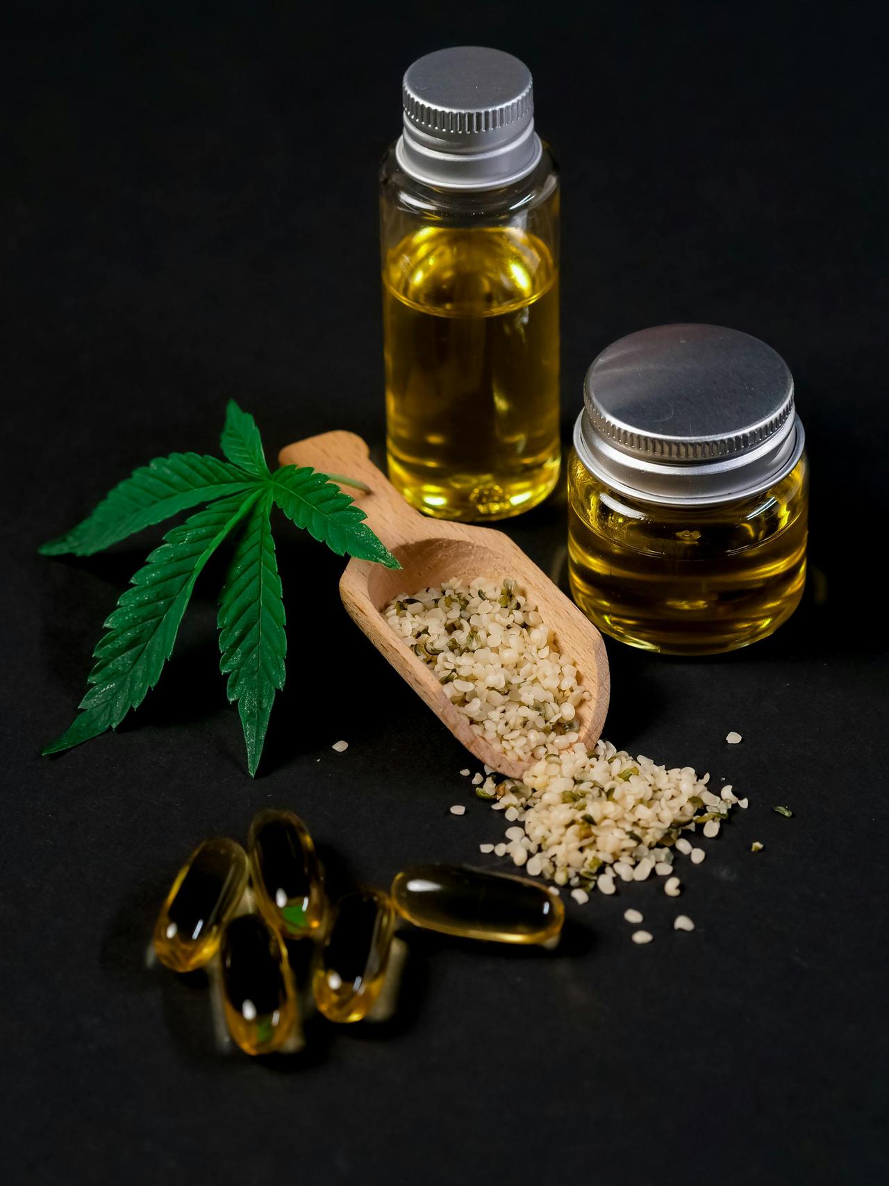 A set of CBD products at a Maine dispensary including oil, capsules, hemp seeds, and a cannabis leaf, presented on a dark backdrop.