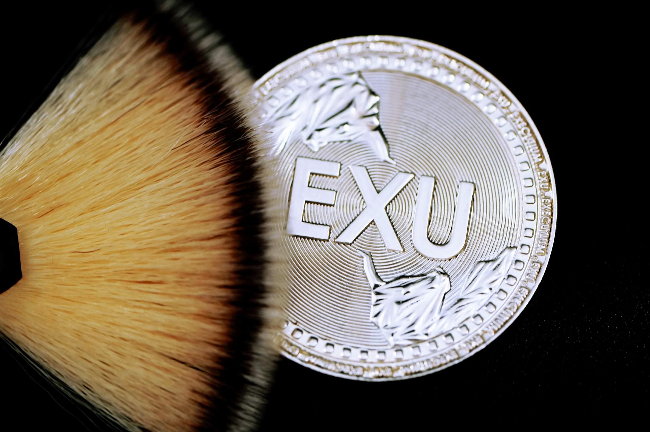 EXU silver coin is under a cosmetic brush