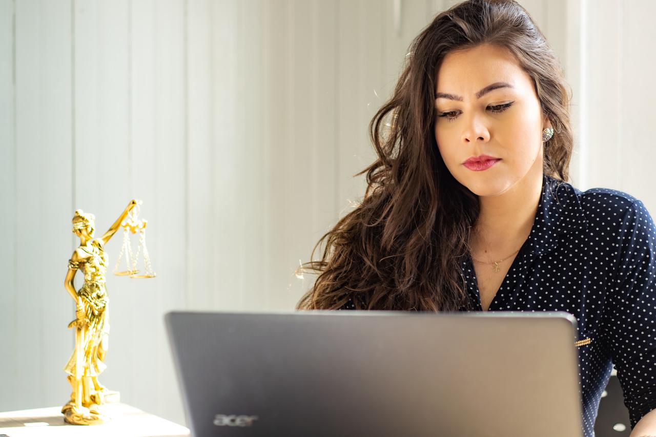 A woman working on a computer. Doing your due diligence is critical when preparing for your DMV hearing in Sacramento.