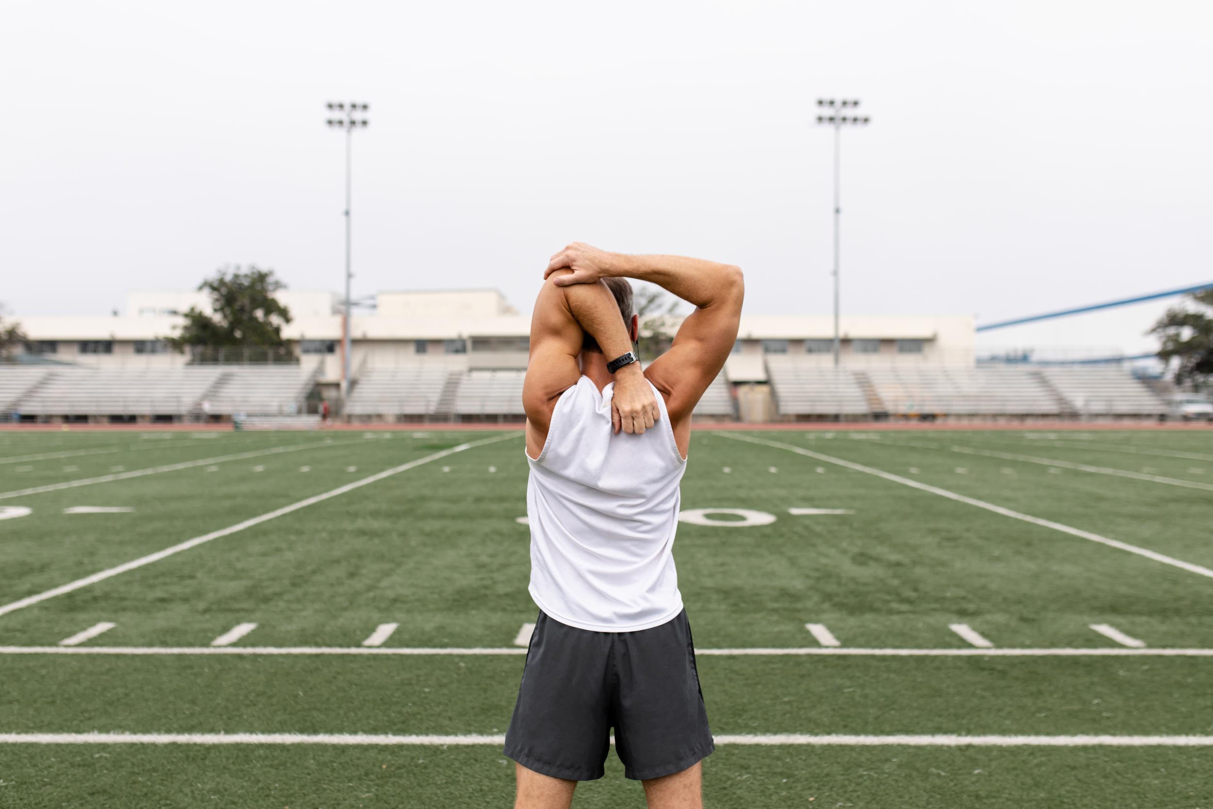athletic-man-stretching-arms-on-sports-field-2026-03-08-23-05-50-utc.jpg