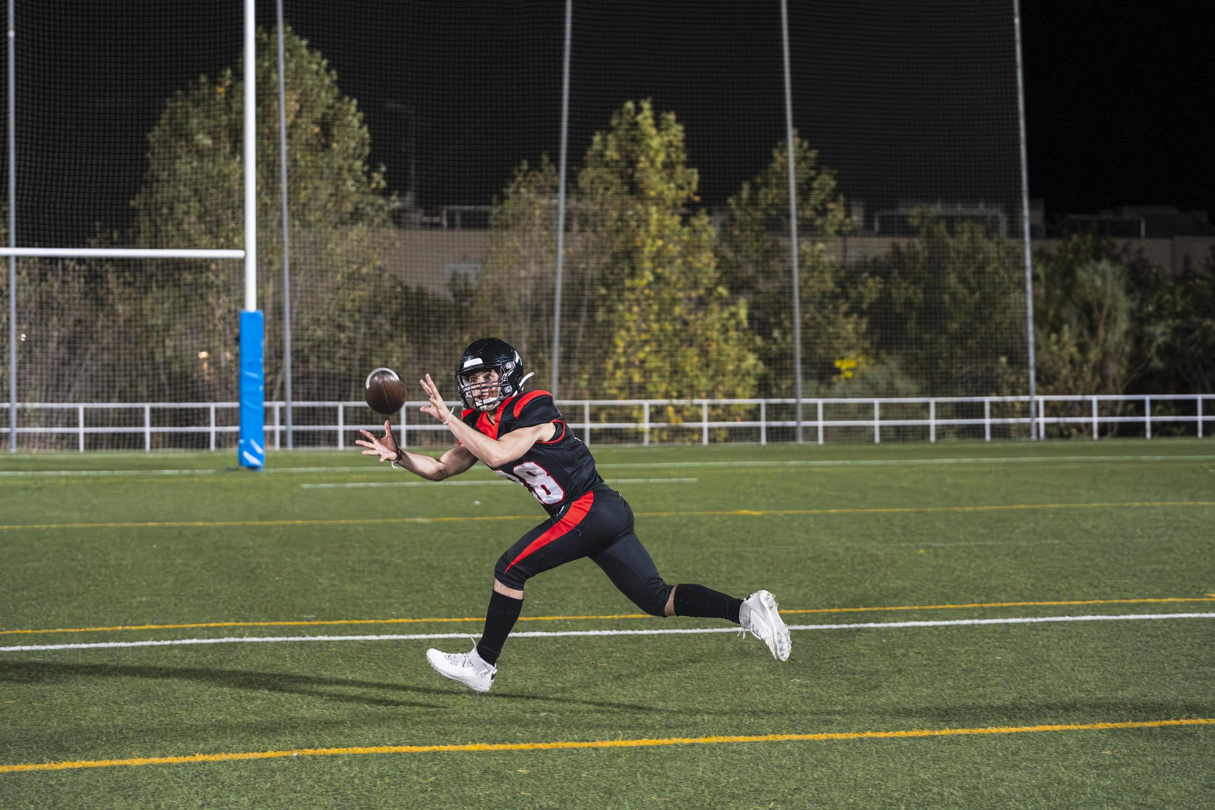 football-player-catching-a-pass-under-stadium-ligh-2026-01-09-12-13-44-utc.jpg
