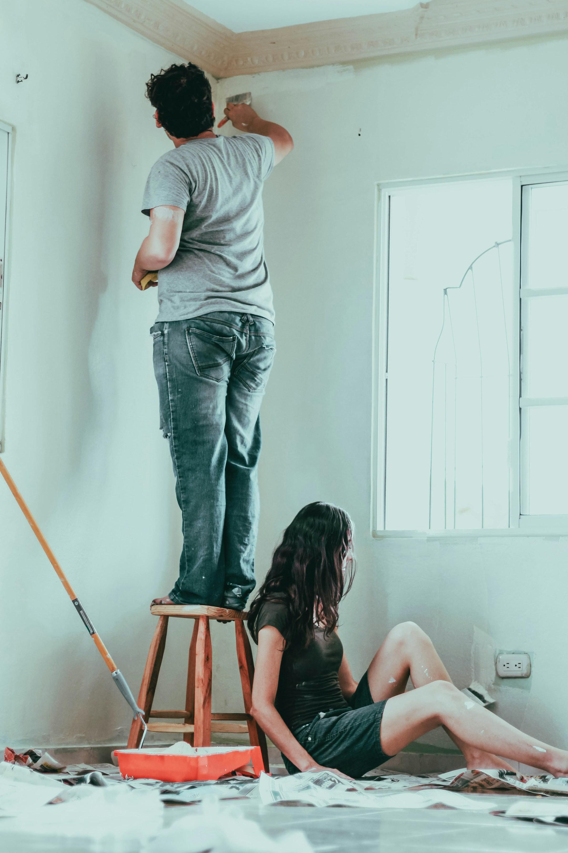 Pareja pintando su nuevo hogar.