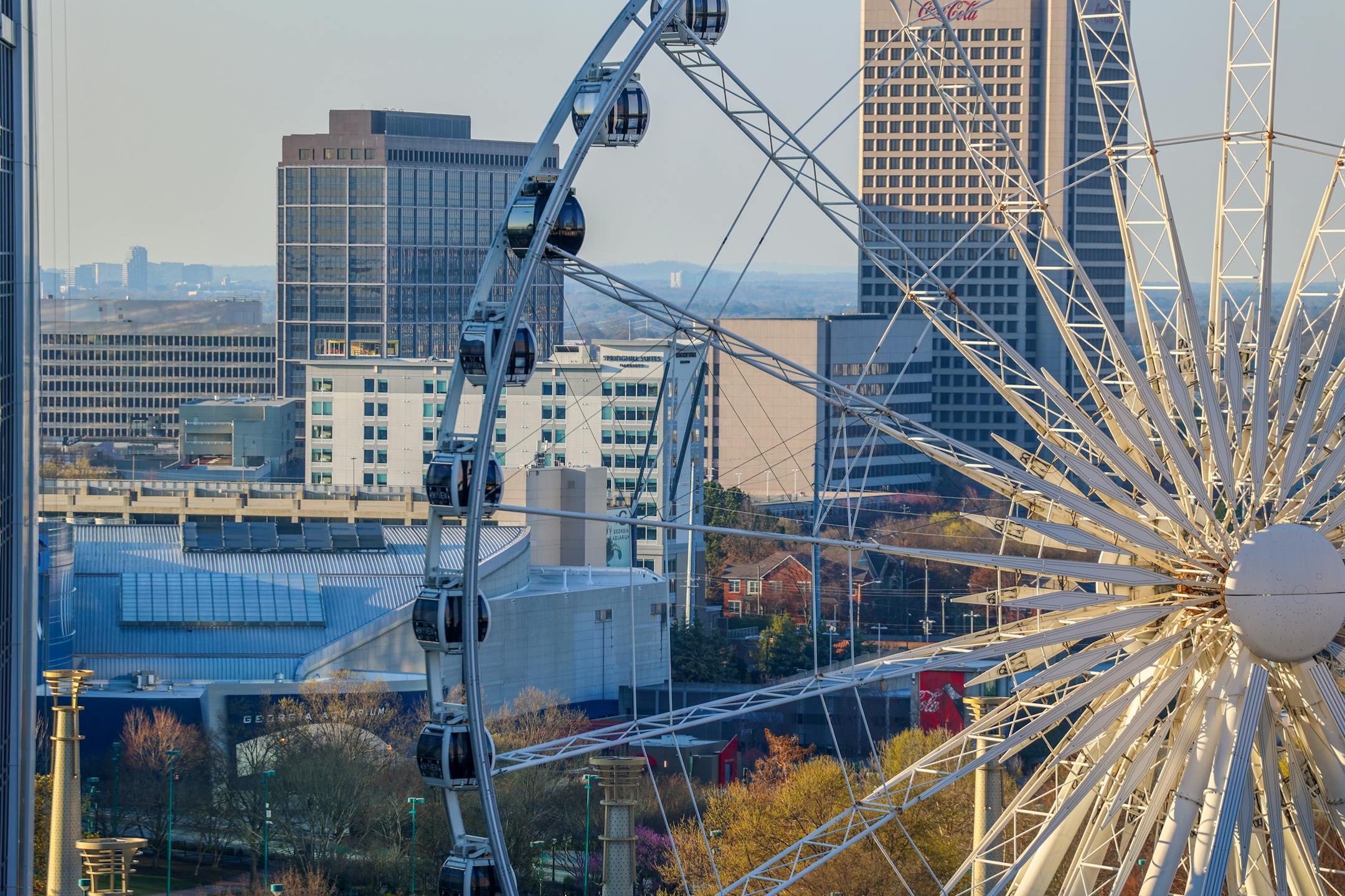Beautiful aerial view of Atlanta's skyline with a prominent Ferris wheel during the day.