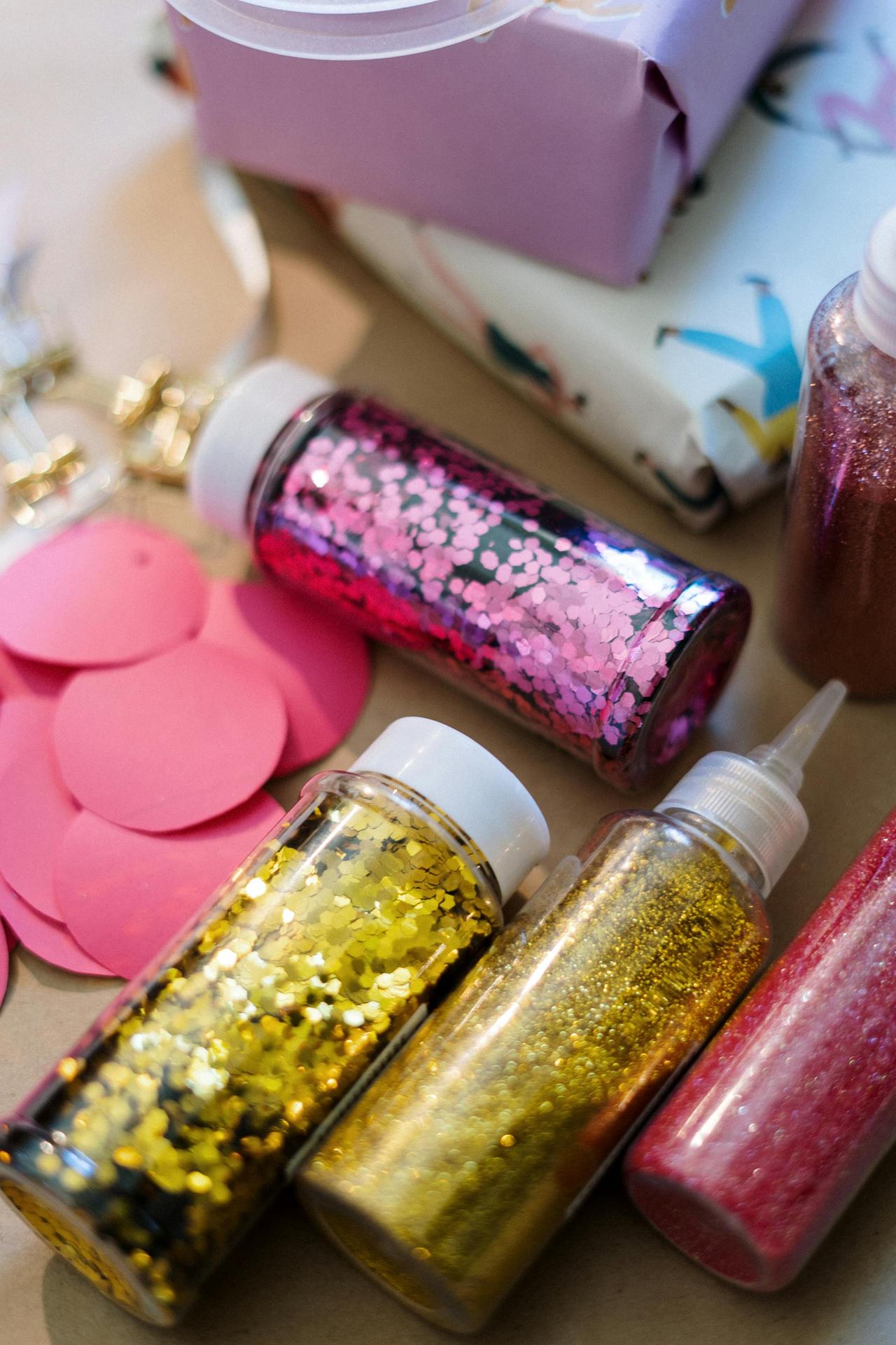 Vibrant glitter bottles on a crafting table, perfect for DIY projects and creative design.