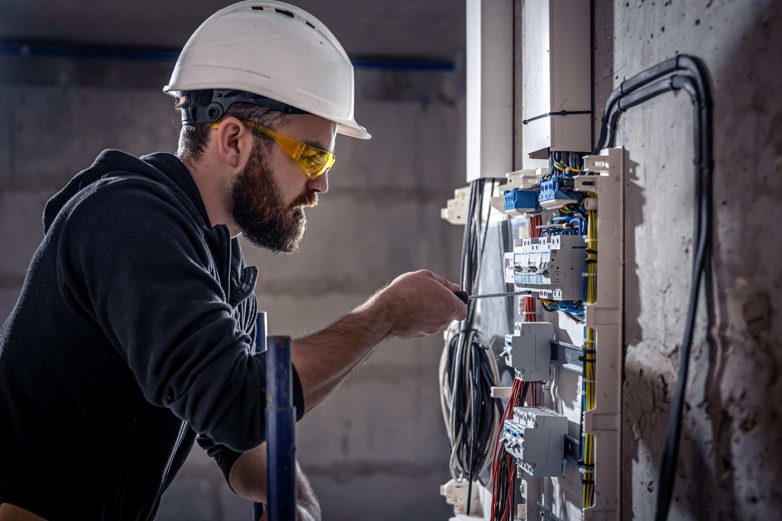 a-male-electrician-works-in-a-switchboard-with-an-2025-03-13-21-43-21-utc.jpg