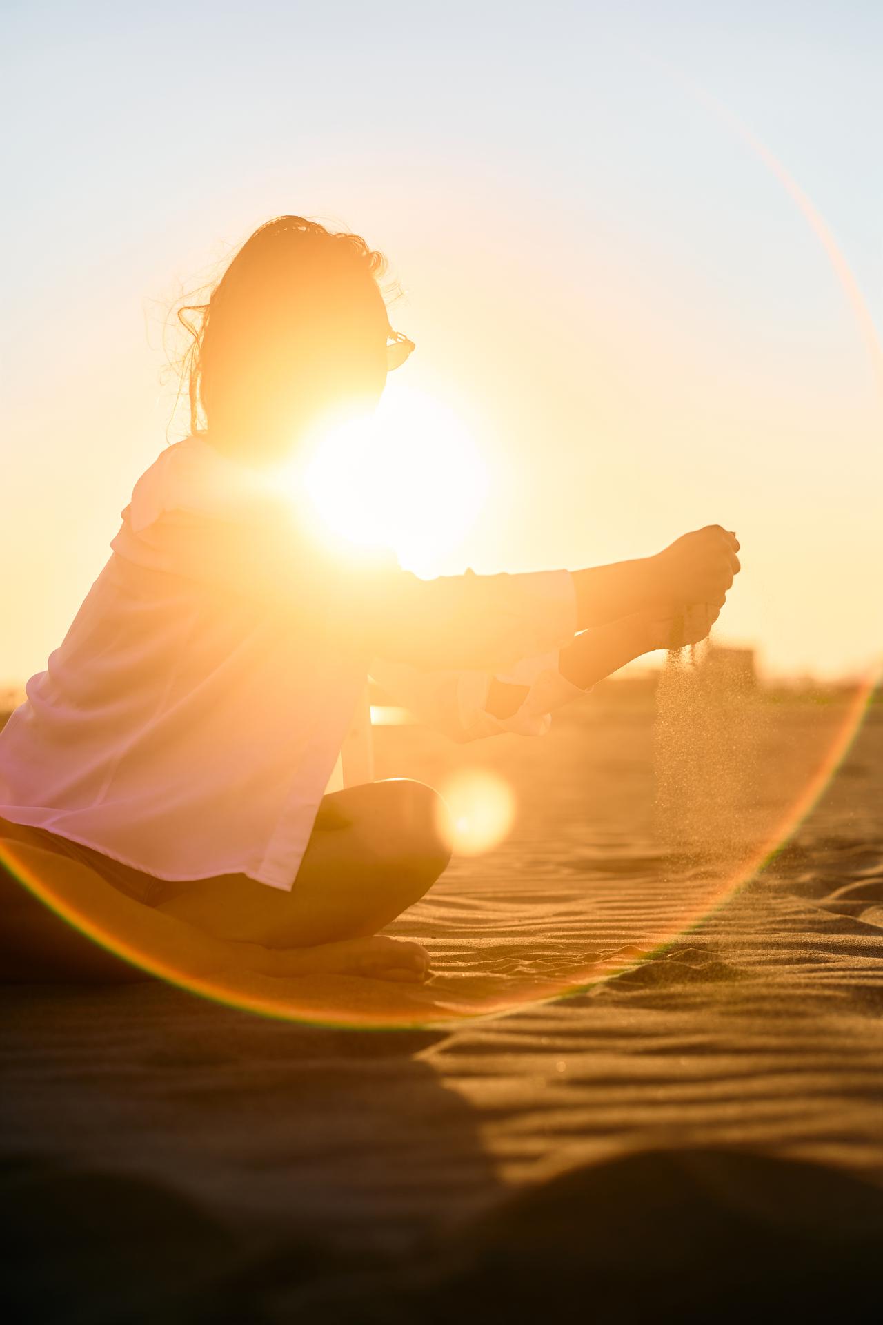 woman-dropping-sand-from-her-hands-on-the-beach-at-2024-12-13-21-05-31-utc.jpg