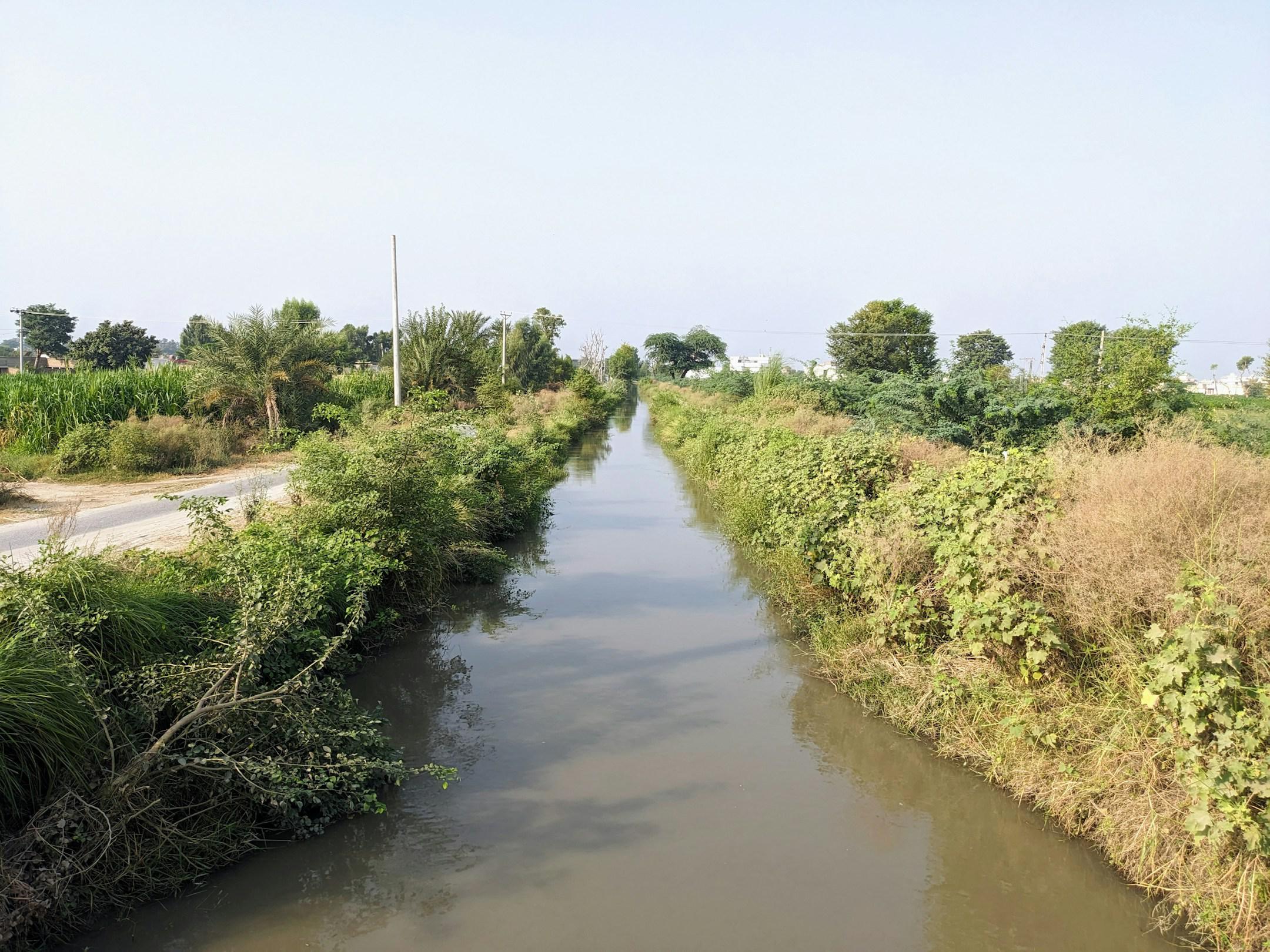 water canal, meticulously engineered, courses through the terrain, efficiently transporting vital water resources for irrigation, transportation, and commerce. Its structured flow embodies the synergy of human innovation with nature's necessity.
