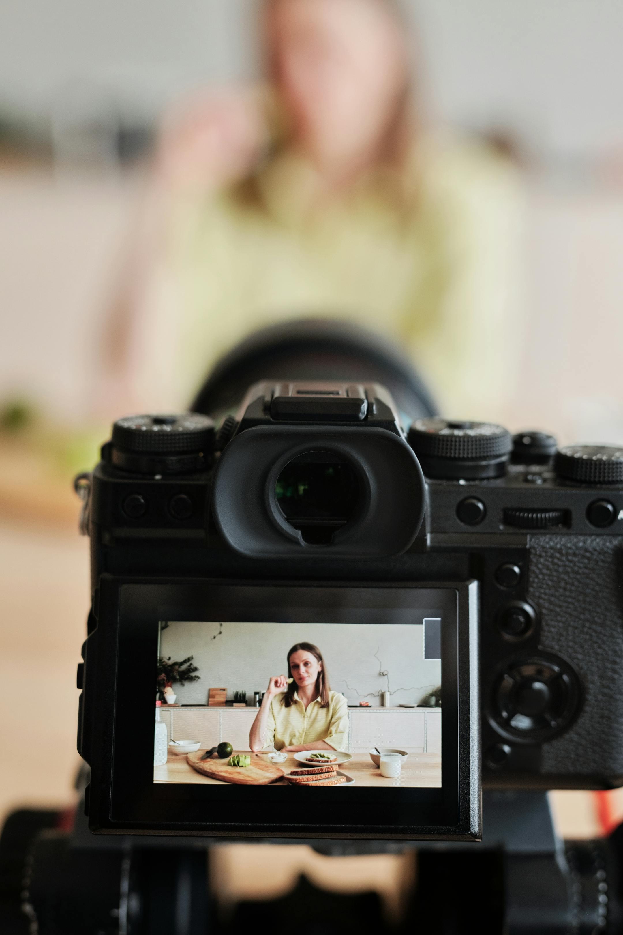 Close-up of a woman filming a cooking vlog in her kitchen.