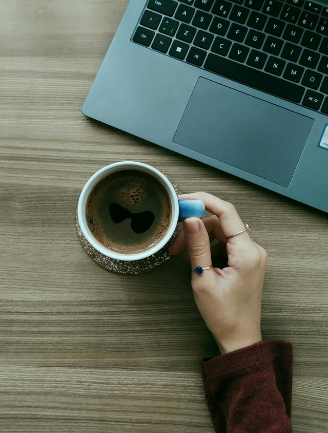 A cozy workspace with a coffee cup and laptop, portraying a calm, productive environment.