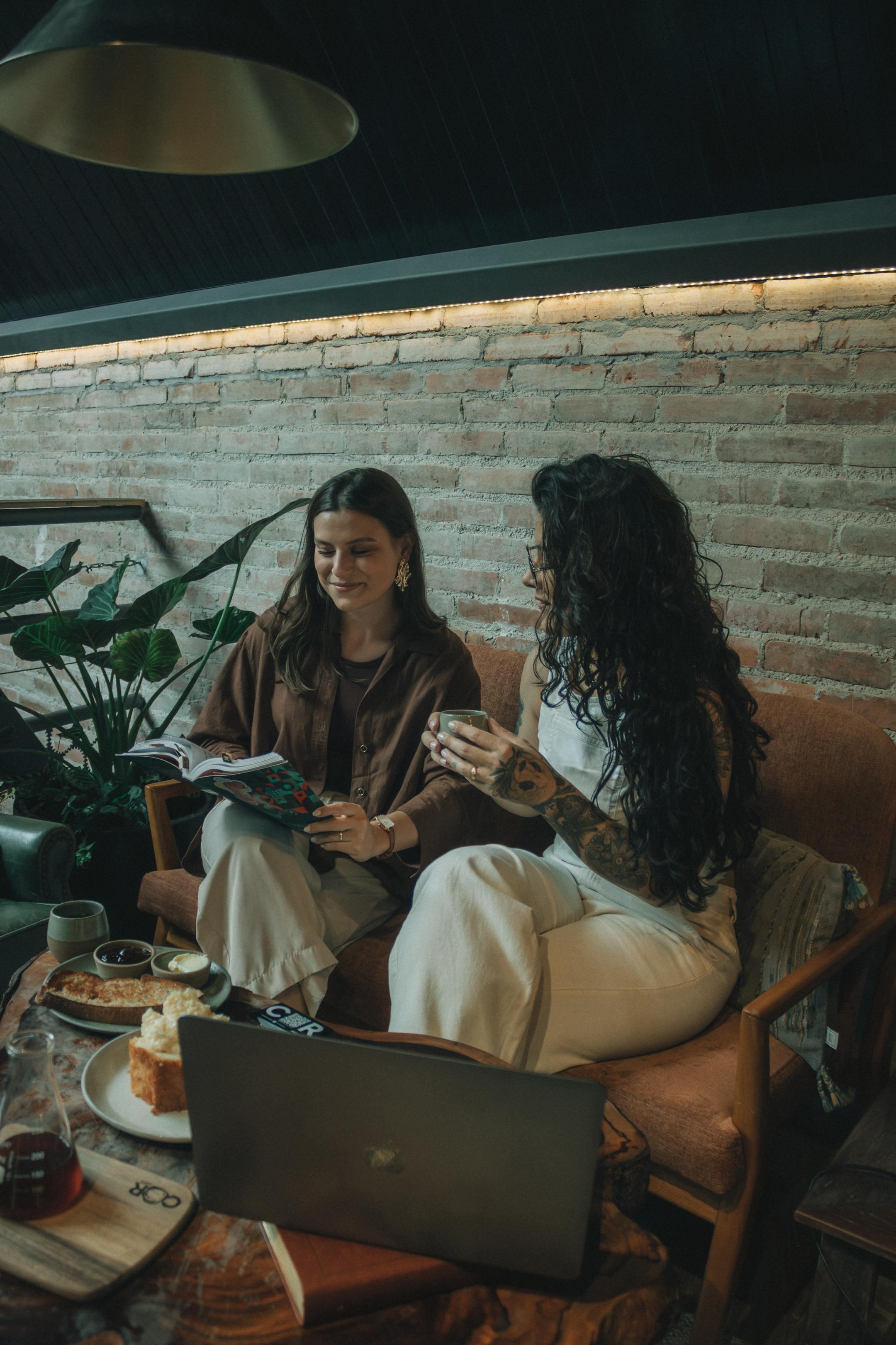 Two women having a casual meeting over coffee in a cozy cafe setting.