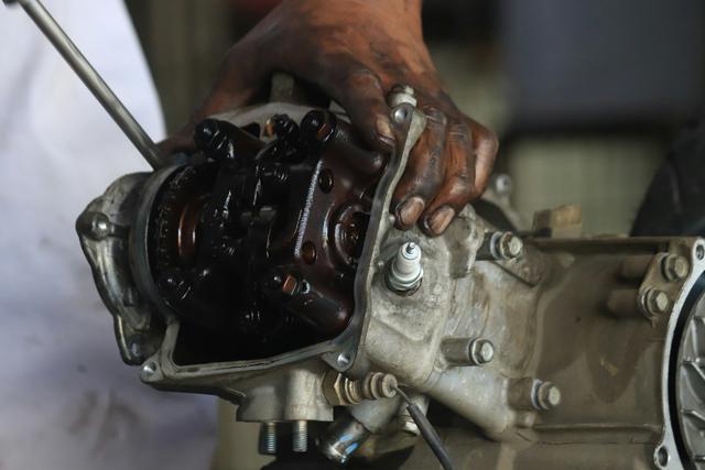 a technician is repairing a motorcycle engine at the Ahas Jatilawang workshop