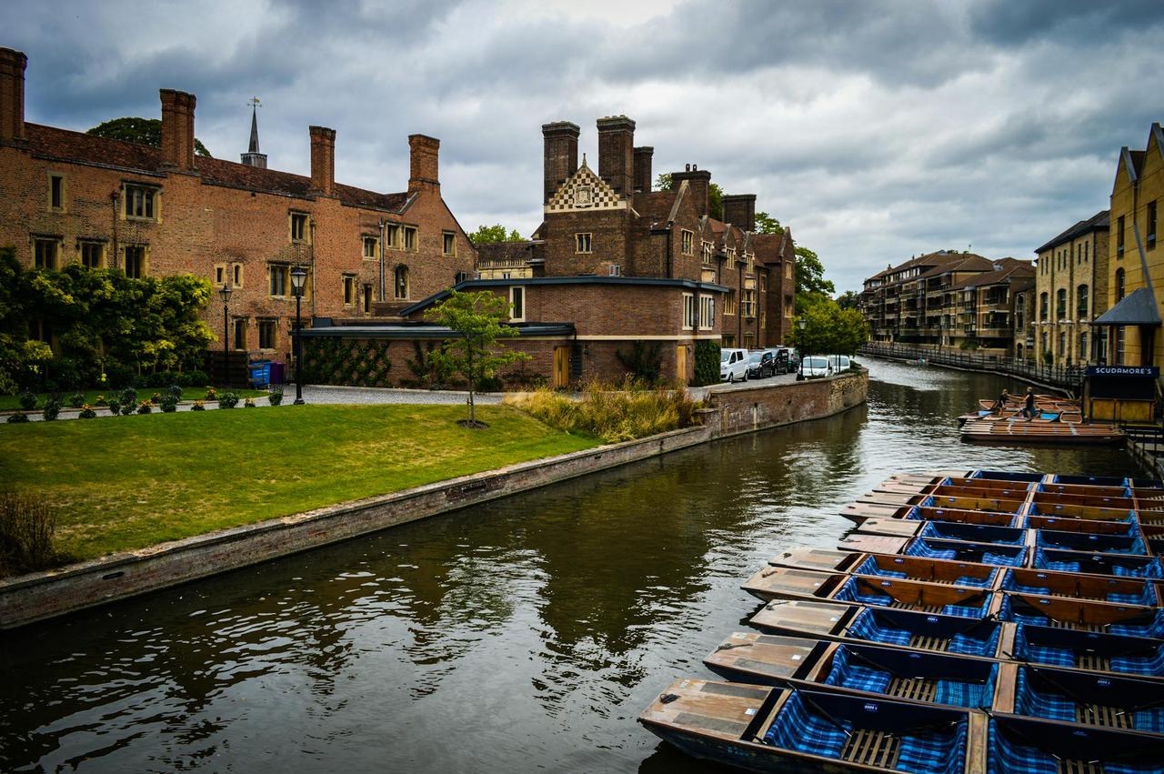 Scenic view of the River Cam with punts and historic architecture in Cambridge, UK.