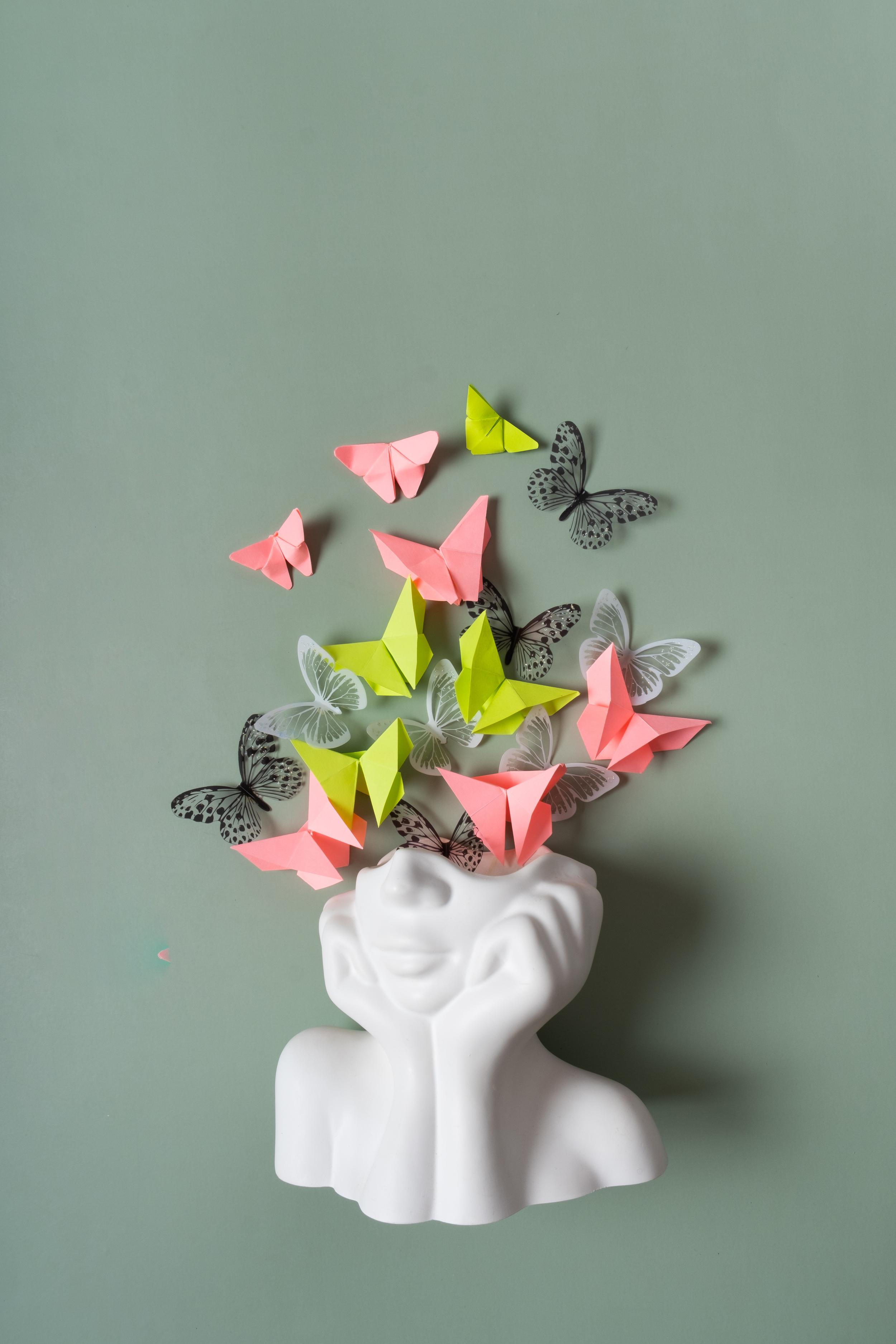 Figurine of a head with paper butterflies coming out
