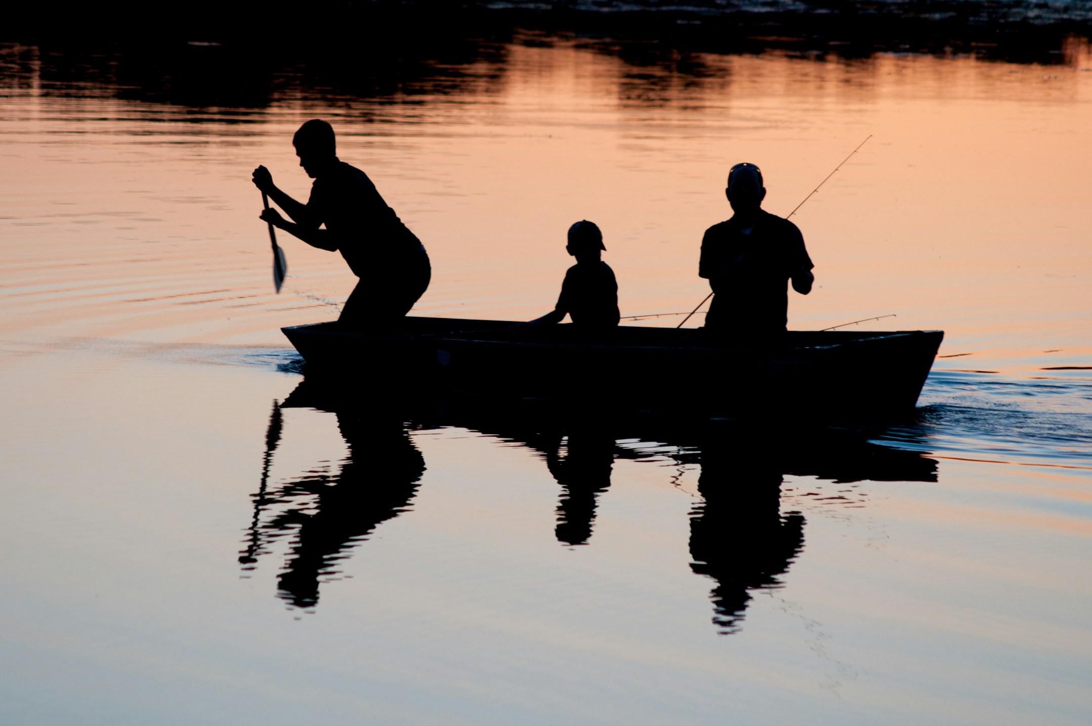 My best friend at the paddle, my nephew in the middle and my cousin messing with his pole. Just a little lake in the middle of nowhere, in a boat with a slow leak.