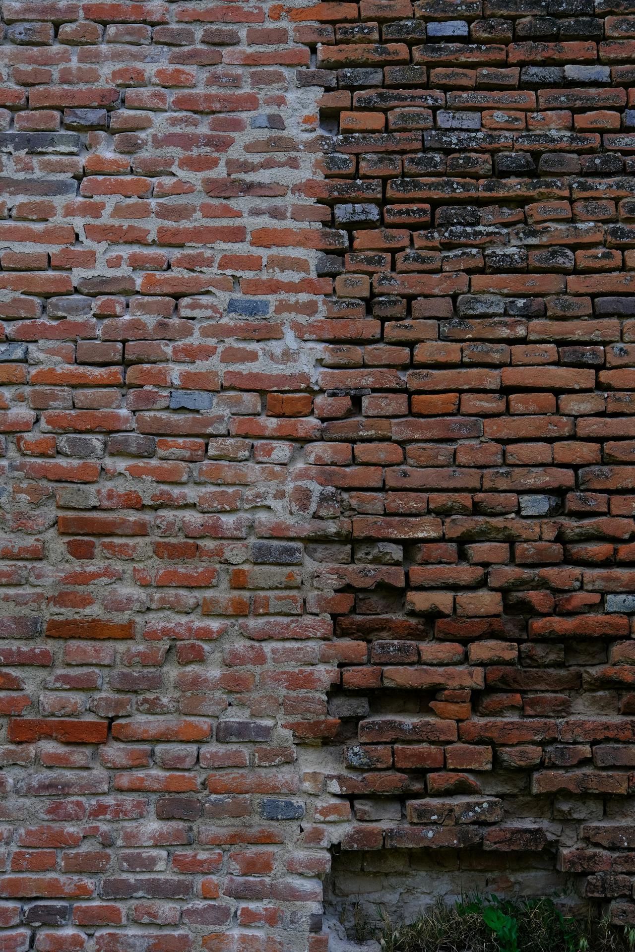A brick wall separated by two shades of orange bricks.
